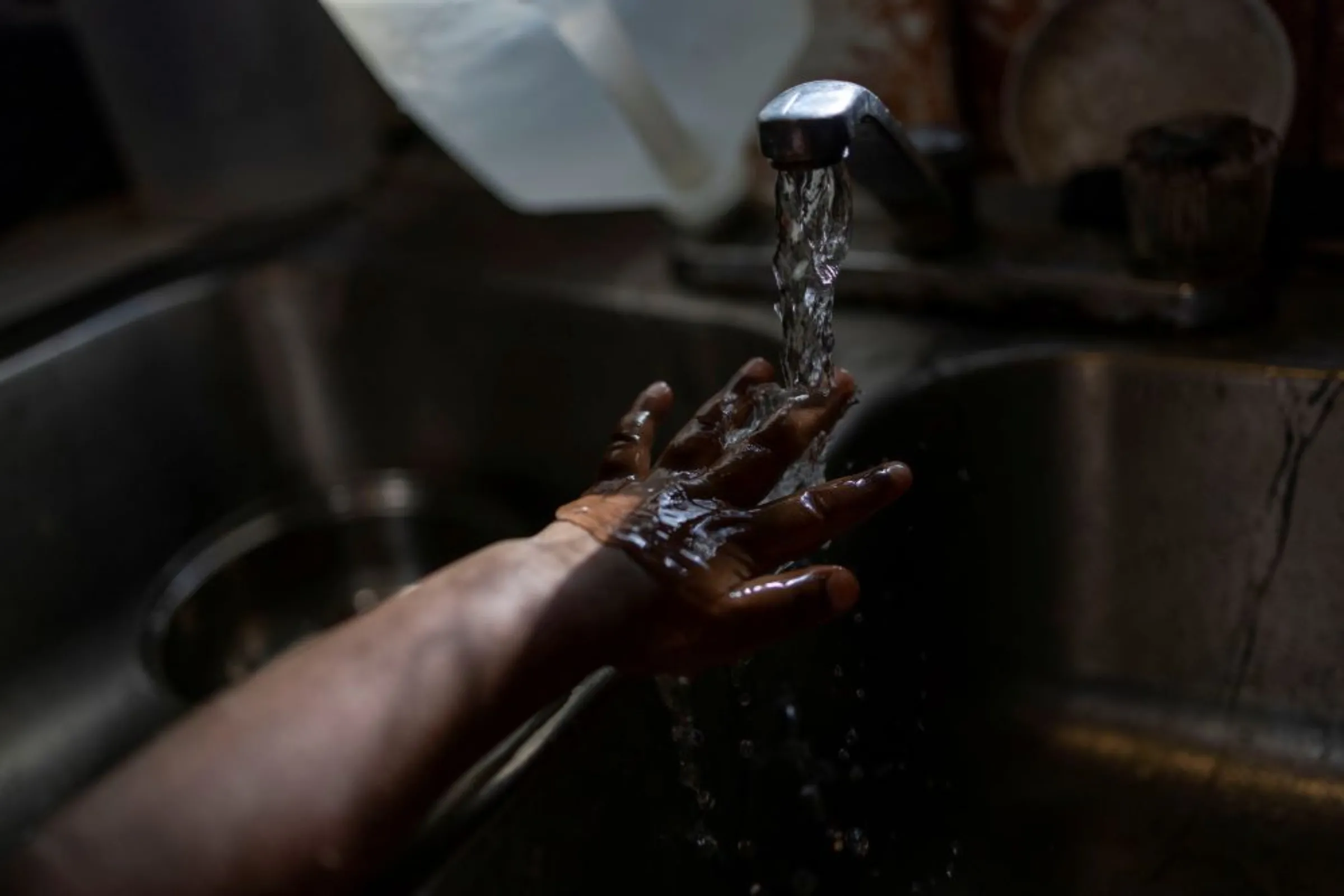Water is seen running from a faucet as a youngster washes her hand in Jackson, Mississippi, U.S., September 2, 2022