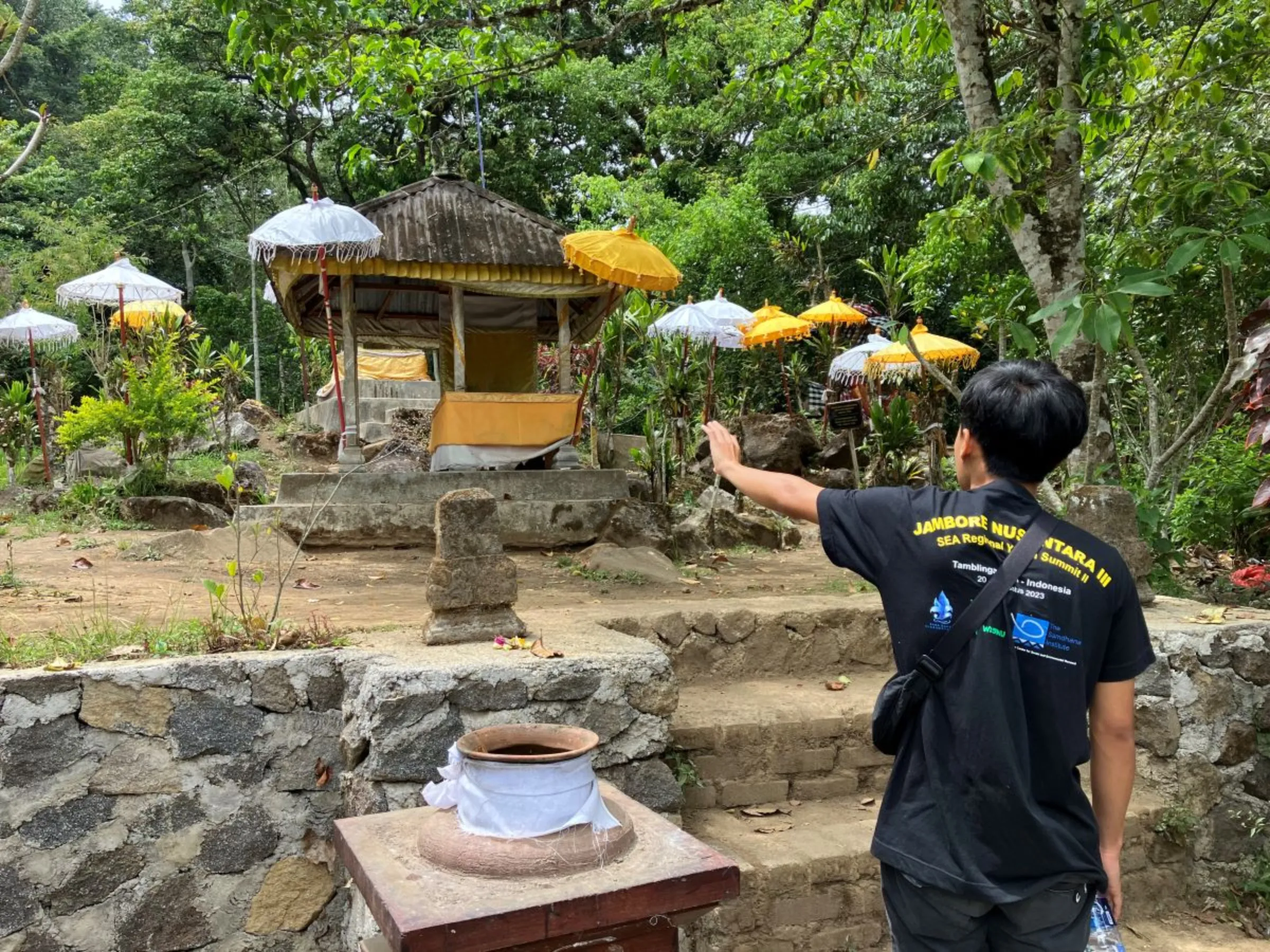 Youth leader and guide Putu Willy Suputra of the Adat Dalem Tamblingan Indigenous community talks about a temple in the Alas Mertajati Forest in northern Bali, Indonesia on Sept 19, 2023. Thomson Reuters Foundation/Michael Taylor