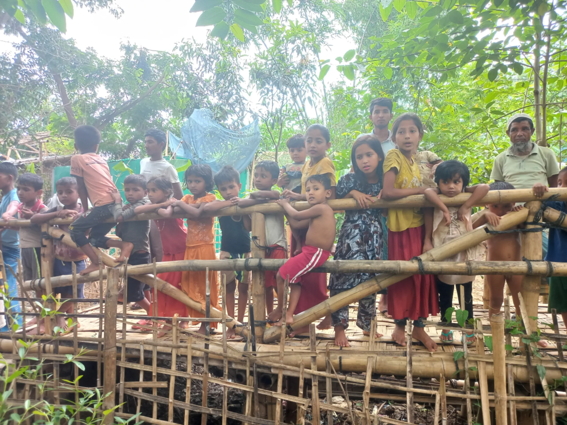Children gather on a bridge in the Rohingya camp in Ukhiya, May 7, 2024, Cox's Bazar, Bangladesh. Thomson Reuters Foundation/Md Tahmid Zami