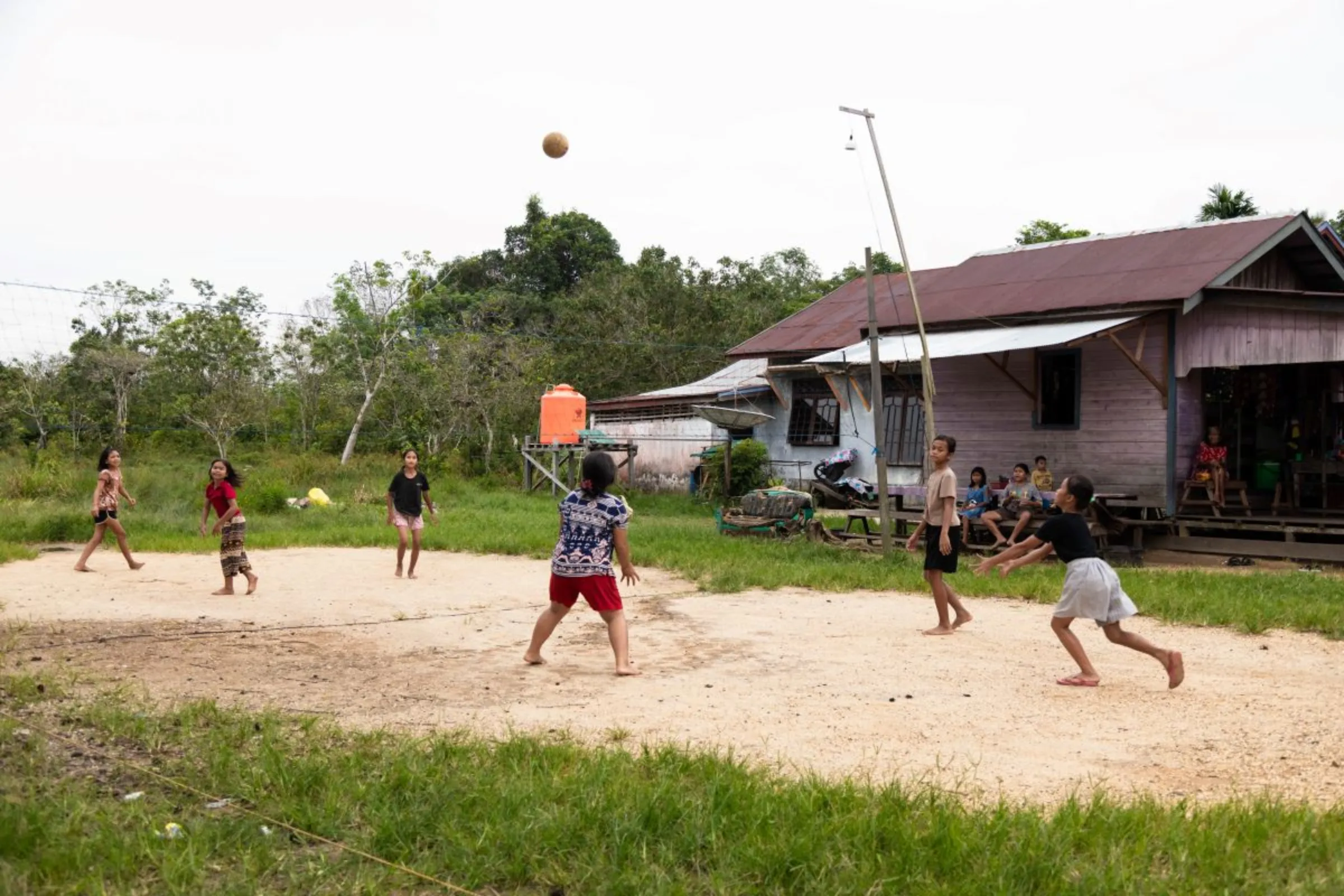 A group of children play volleyball at Tawai Baru village in Central Kalimantan, Indonesia on June 20, 2023. This village has been frequently hit by floods since the forest area was cleared for the food security program. Thomson Reuters Foundation/Irene Barlian