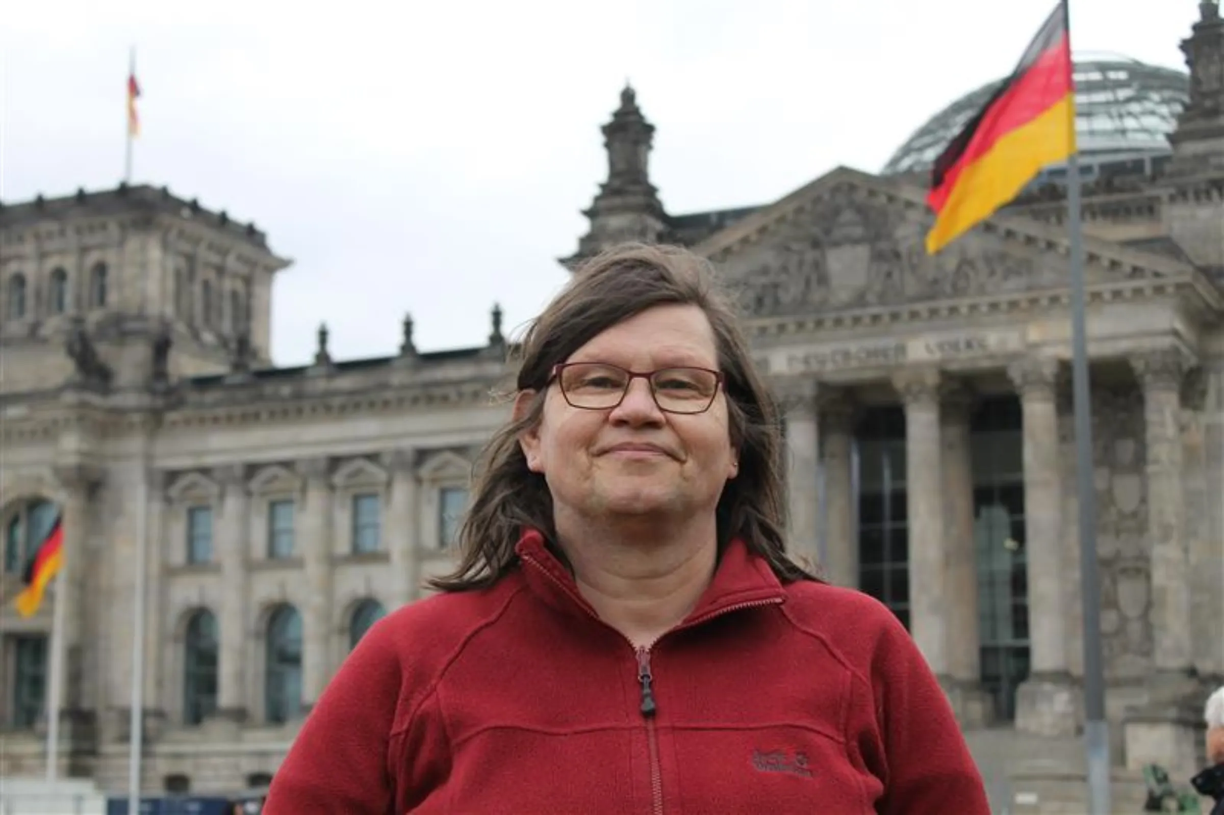 Trans activist Cathrin Ramelow, 61, poses in front of the German parliament in Berlin, on April 6, 2022. Thomson Reuters Foundation/Enrique Anarte.