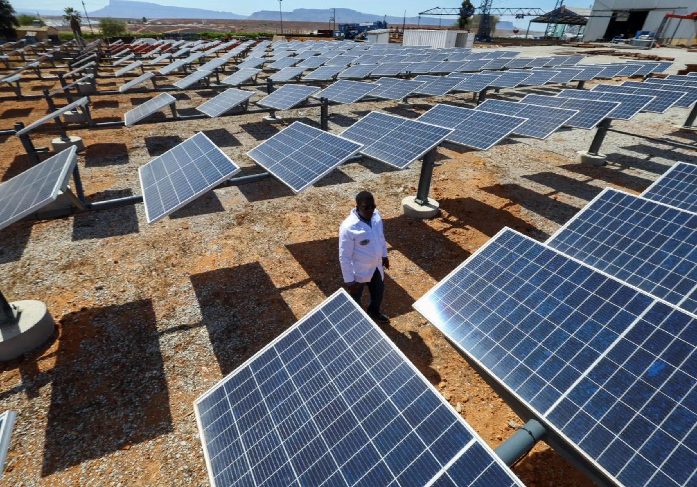 A man looks at the solar panels at the site where Keren Energy constructed the first proof of concept of green hydrogen production facility in Africa at Namaqua Engineering in Vredendal, in collaboration with The Green Hydrogen Institute for Advanced Materials Chemistry (SAIAMC) at the University of the Western Cape, South Africa, November 15, 2022