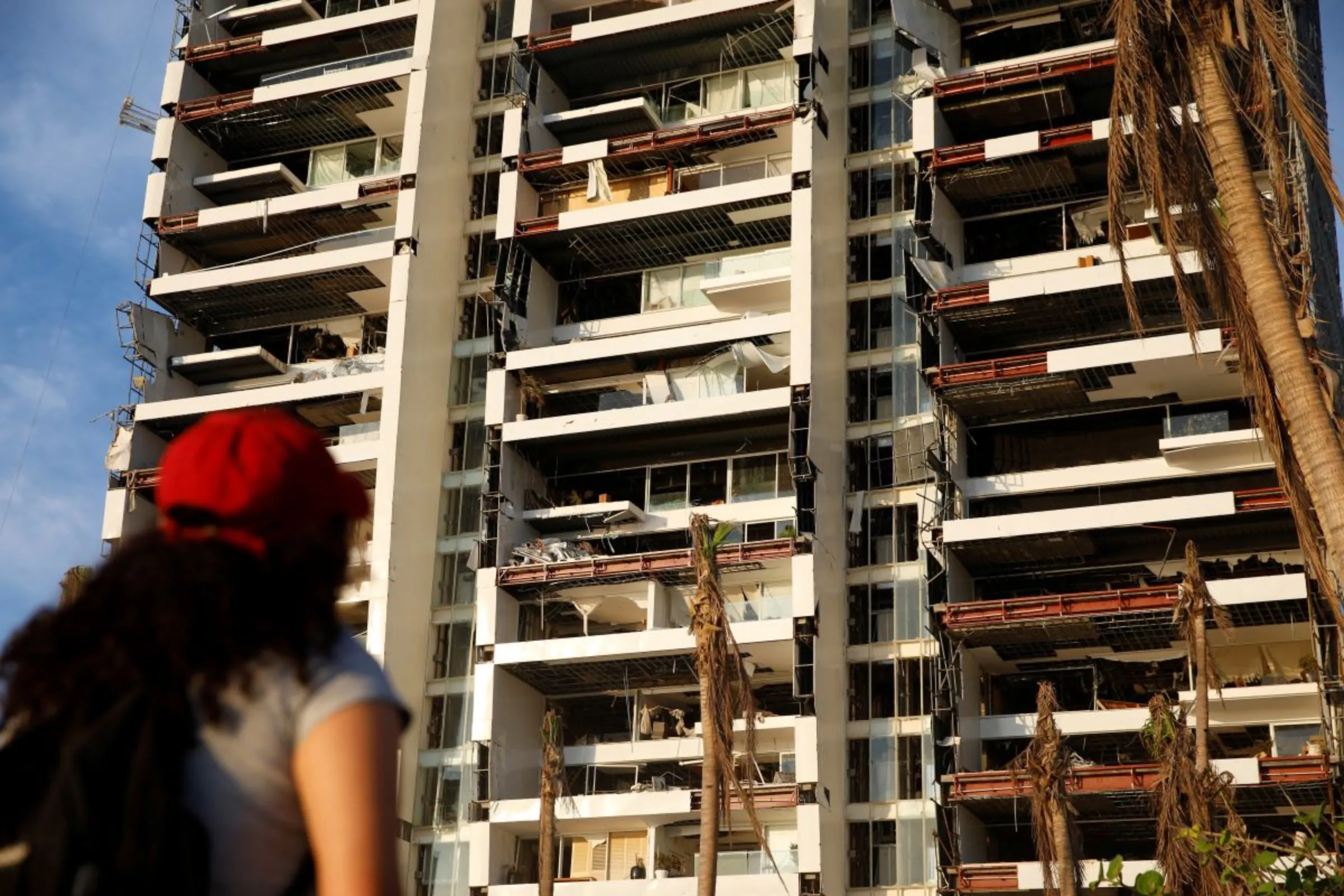 A woman looks at a damaged building at Punta Diamante beach a month after Hurricane Otis hit Acapulco, Mexico November 25, 2023. REUTERS/Raquel Cunha