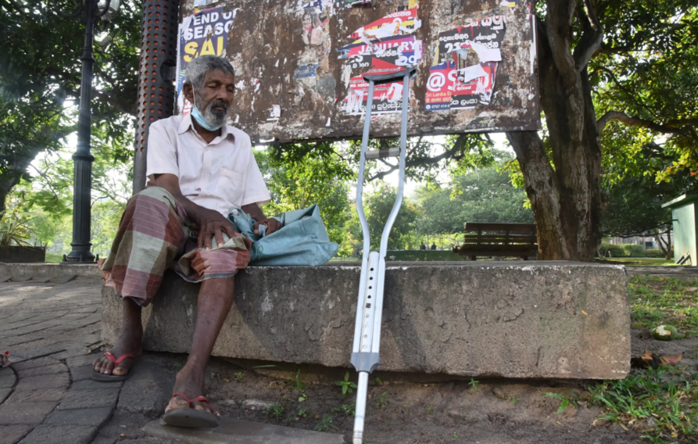 Senior citizen Kiri Banda rests at a public park after walking around and begging for change in Colombo, Sri Lanka on January 30, 2023