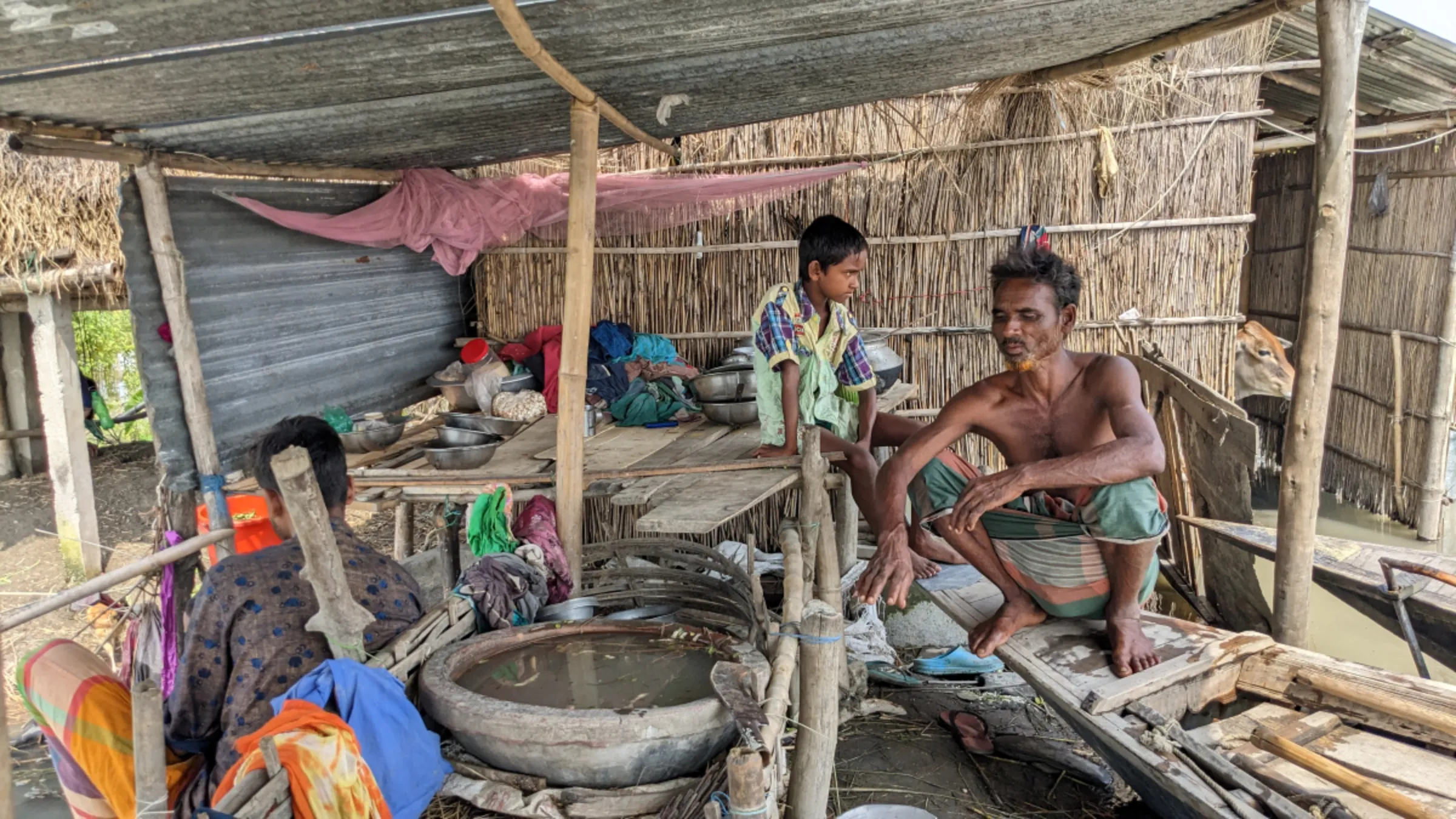 A family carries on with daily life in their flooded house in Kurigram, northern Bangladesh, September 15, 2023