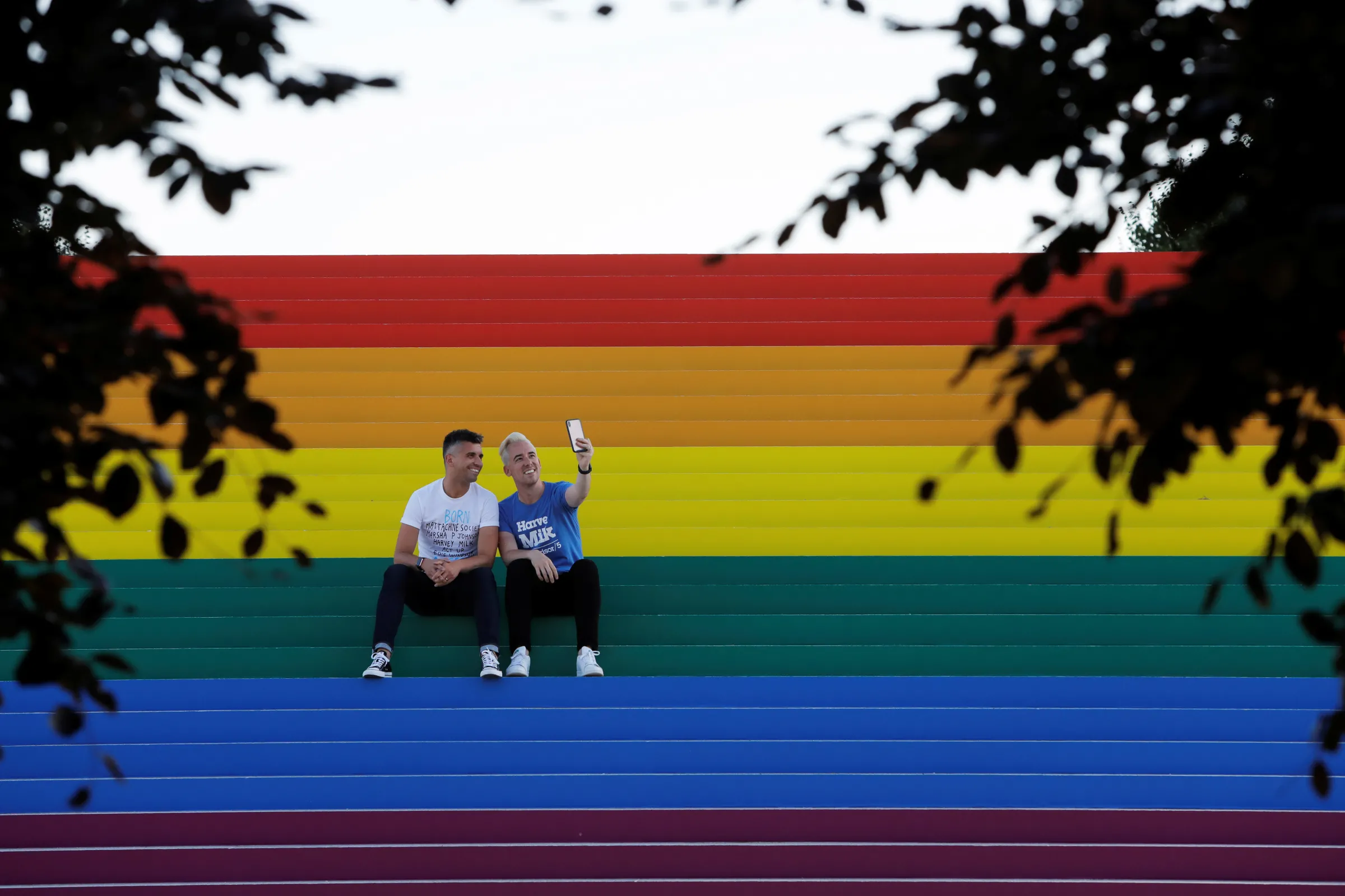 Two men take a selfie on a giant LGBTQ Pride Flag installed on the steps of Franklin D. Roosevelt Four Freedoms State Park in New York City, U.S., June 14, 2019. REUTERS/Andrew Kelly