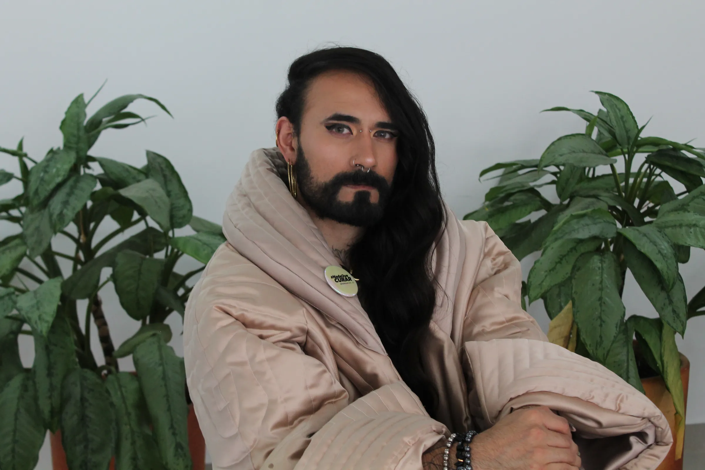 Colombian trans activist Danne Belmont poses for a photo with a pin that reads 'Nada que curar' (nothing to heal, in Spanish) - one of the mottos of the campaign to ban so-called 'conversion therapy' in the South American country - at the offices of the LGBTQ+ rights group Fundación GAAT in Bogotá, on July 24, 2025. Thomson Reuters Foundation/Enrique Anarte