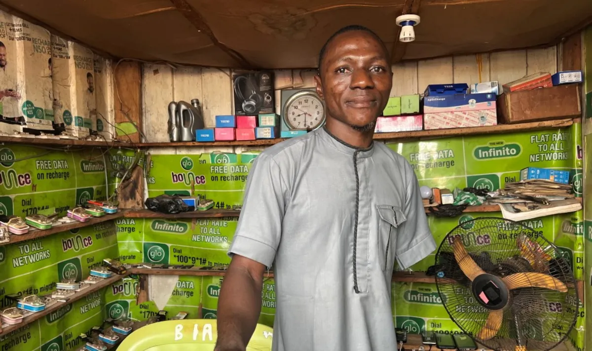 John Dauda Buhari, 25, stands inside his mobile-phone charging shop, which runs on solar power, in Igbabo, Nasarawa, Nigeria, September 27, 2022. Thomson Reuters Foundation/Afolabi Sotunde