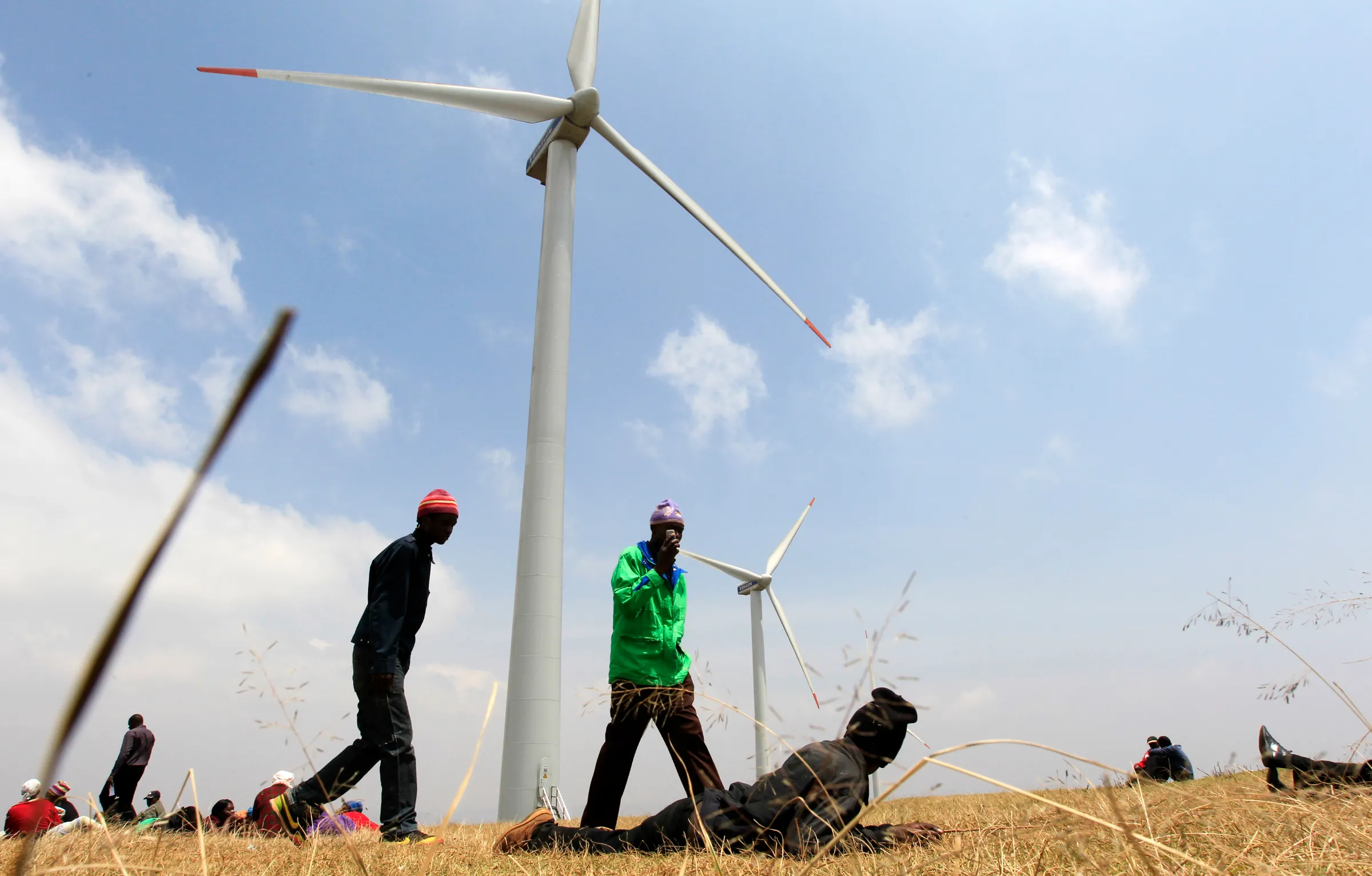 People walk near power-generating wind turbines in Ngong hills, in Nairobi, Kenya, September 8, 2010