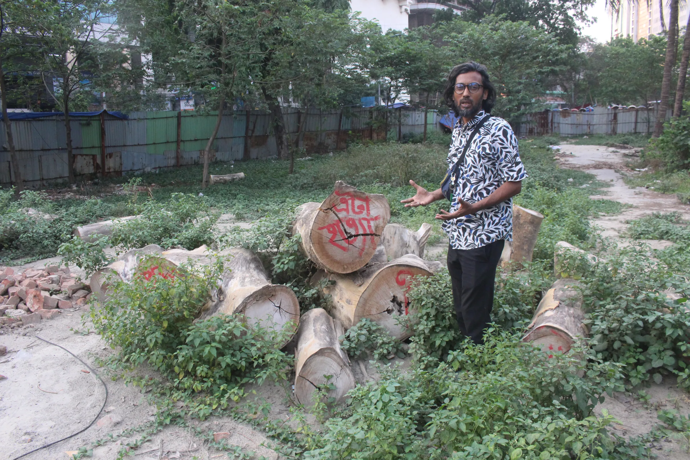 Amirul Rajiv, an art historian and coordinator of Bangladesh Tree Protection Movement, shows the stumps of trees felled at the Panthakunja Park for construction of an elevated expressway, Dhaka, Bangladesh, April 26, 2025. Md. Tahmid Zami/ Thomson Reuters Foundation
