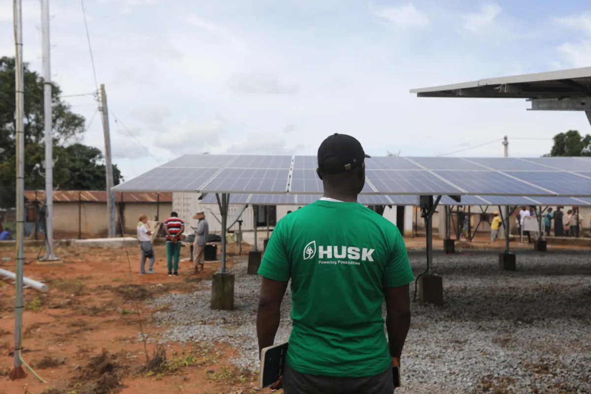A Husk Power employee stands next to solar panels at the company's minigrid in Kiguna, Nasarawa, Nigeria, September 26, 2022. Thomson Reuters Foundation/Afolabi Sotunde