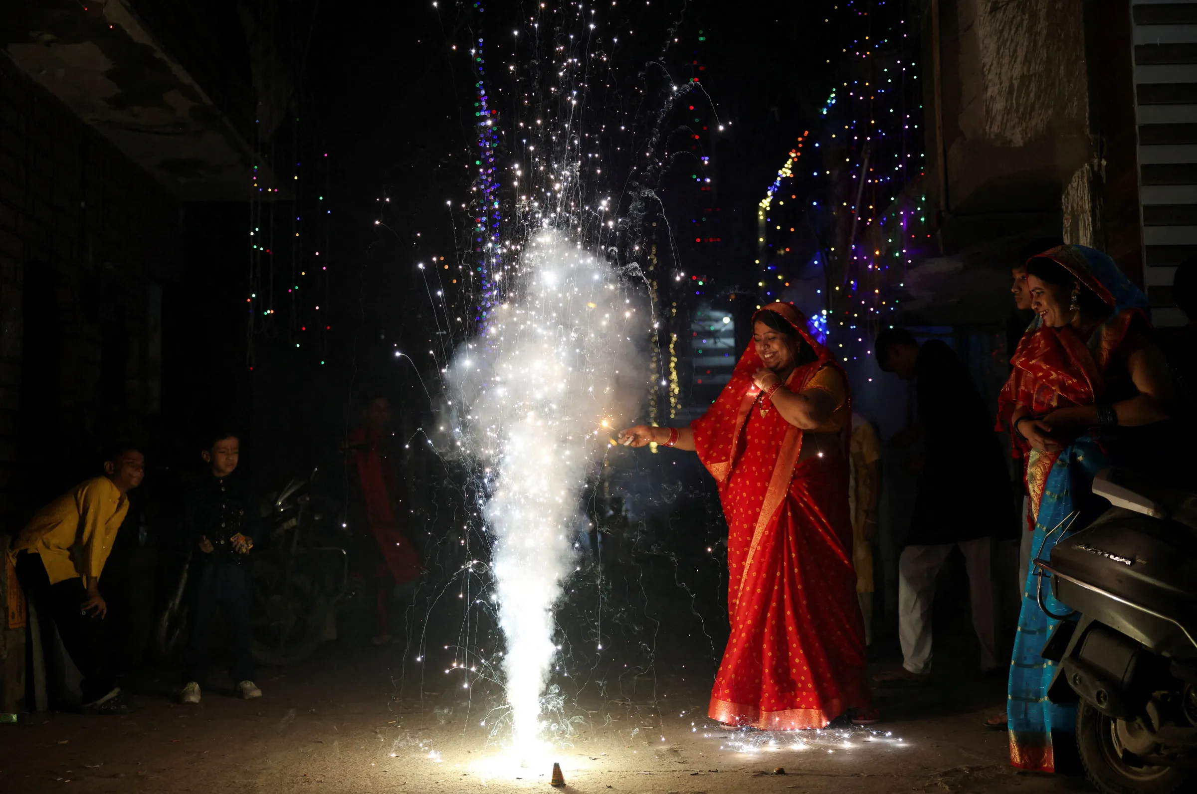 A woman lights fireworks to celebrate Diwali, the Hindu festival of lights, in New Delhi, India, October 20, 2025. REUTERS/Bhawika Chhabra