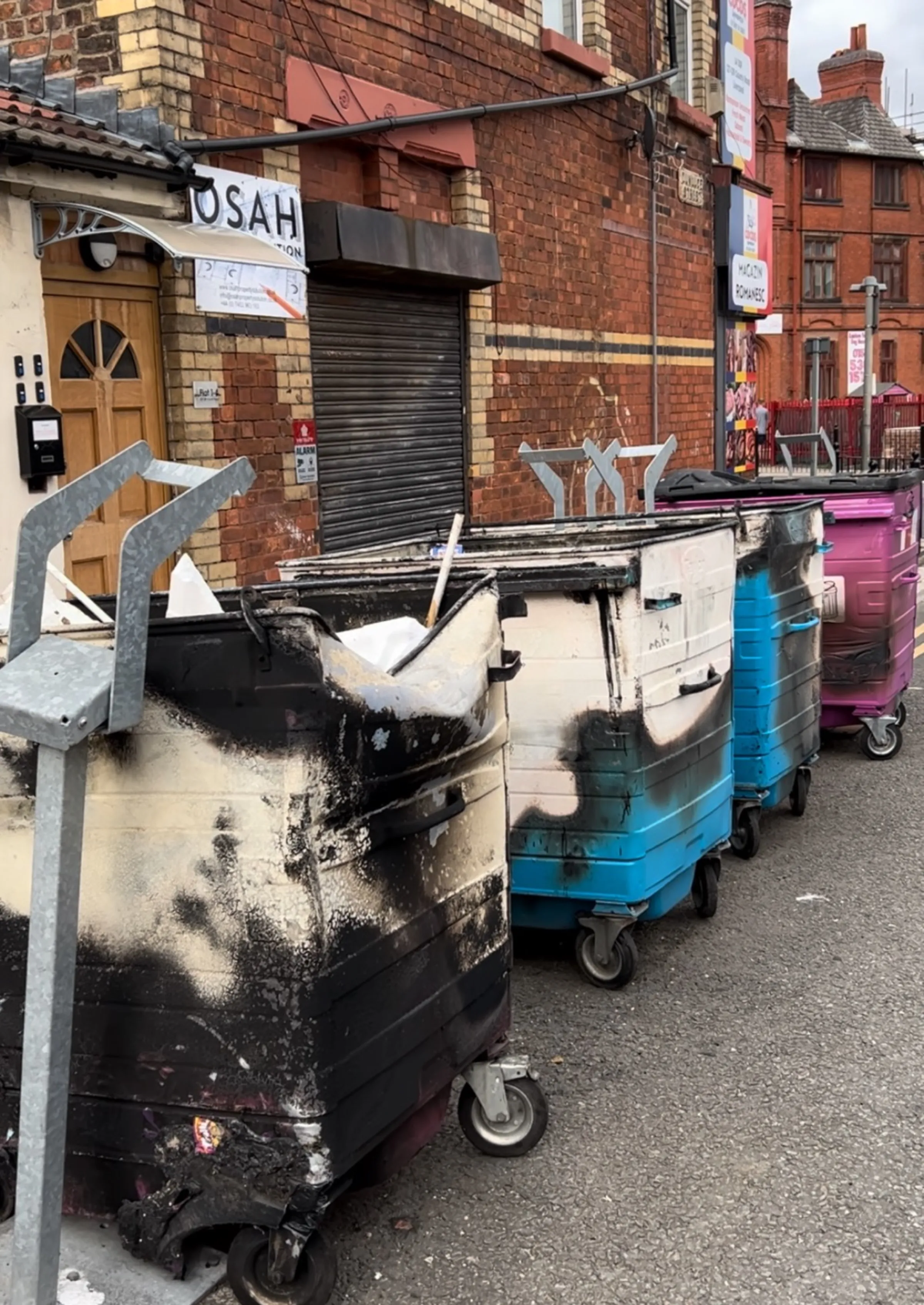 Four burnt out recycling bins stand outside Spellow Lane Library Hub, in Walton, Liverpool, after rioters targeted the area on August 3. August 5, 2024. Thomson Reuters Foundation/Lucy Middleton