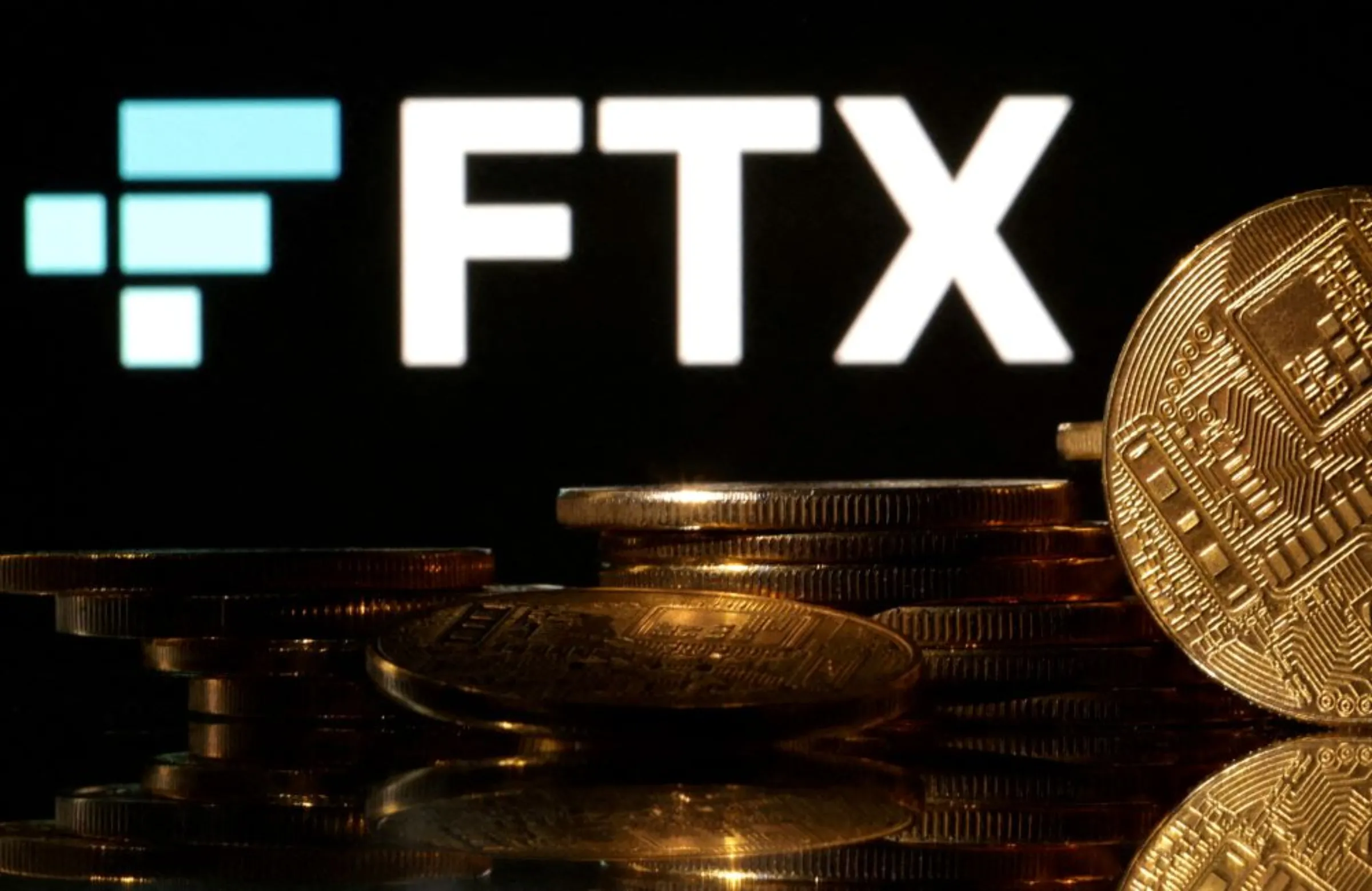 Representations of cryptocurrencies are seen in front of displayed FTX logo in this illustration taken November 10, 2022