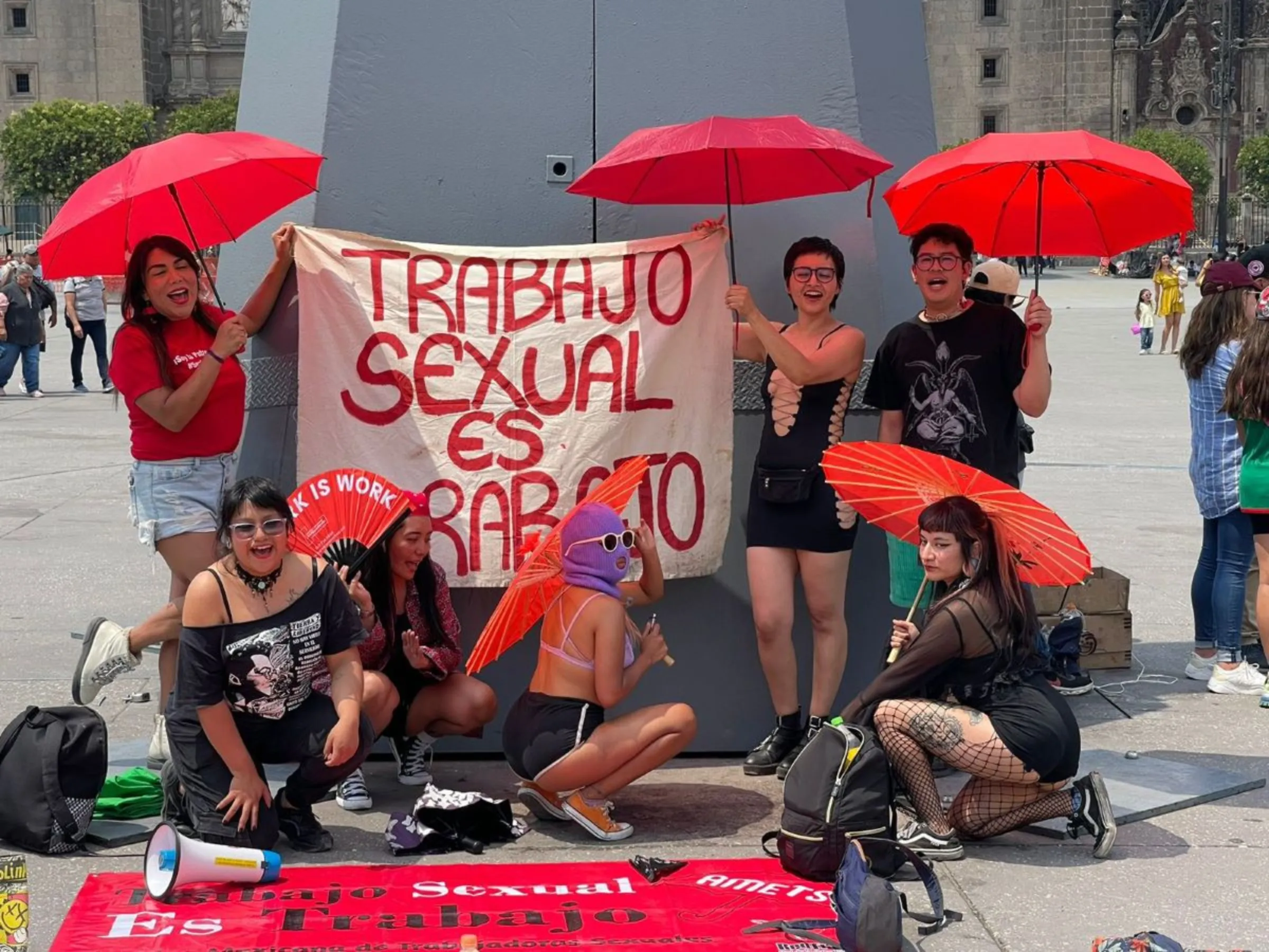 Members from CLaP! pose next to a sign that reads 'Sex work is work' in Mexico City, Mexico, on May 1, 2024. ProDESC/handout via Thomson Reuters Foundation.