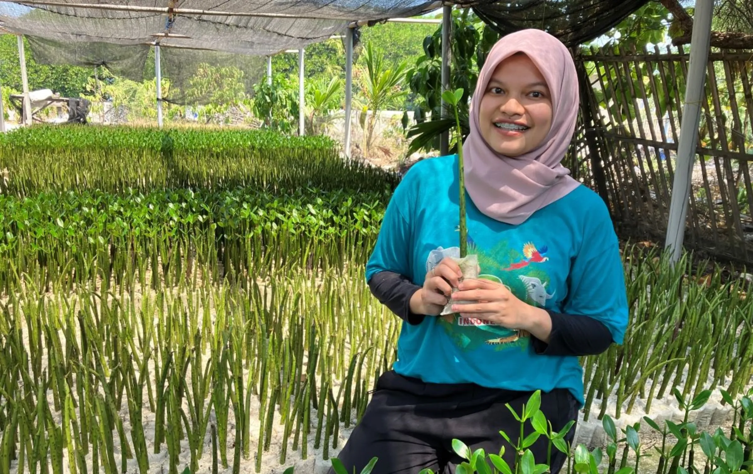 Jakarta resident and Hutan Itu Indonesia volunteer Dwi Bangun at a mangroves planting project along the coastal areas of Harapan island, north of Jakarta, Indonesia on August 10, 2023