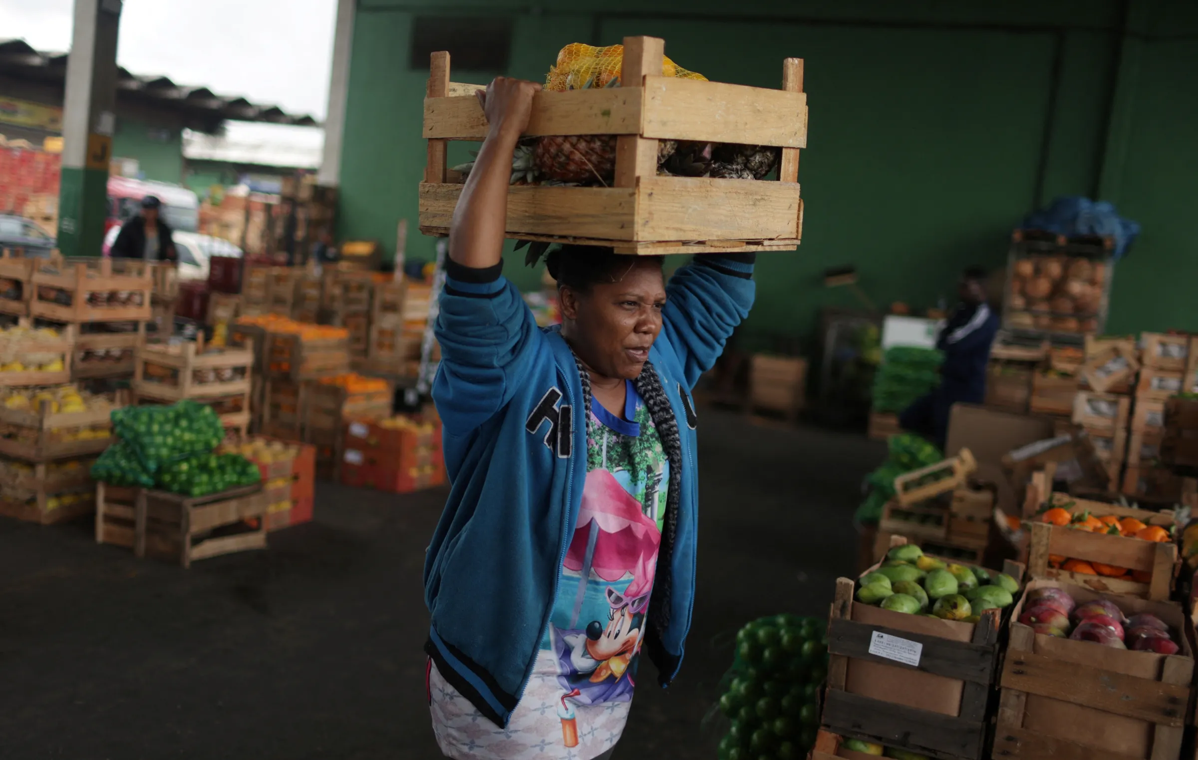 Woman carries a box of fruit and vegetables in Rio de Janeiro, Brazil, August 30, 2022. REUTERS/Pilar Olivares