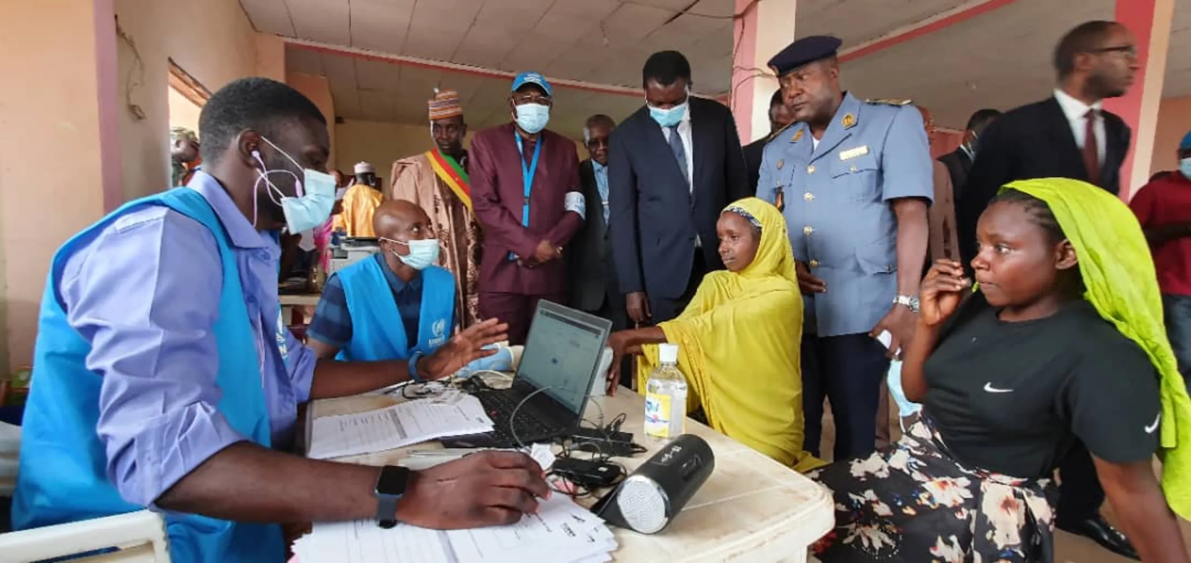 Officials supervise the delivery of digital ID cards to refugees from the Central African Republic at a camp in Cameroon