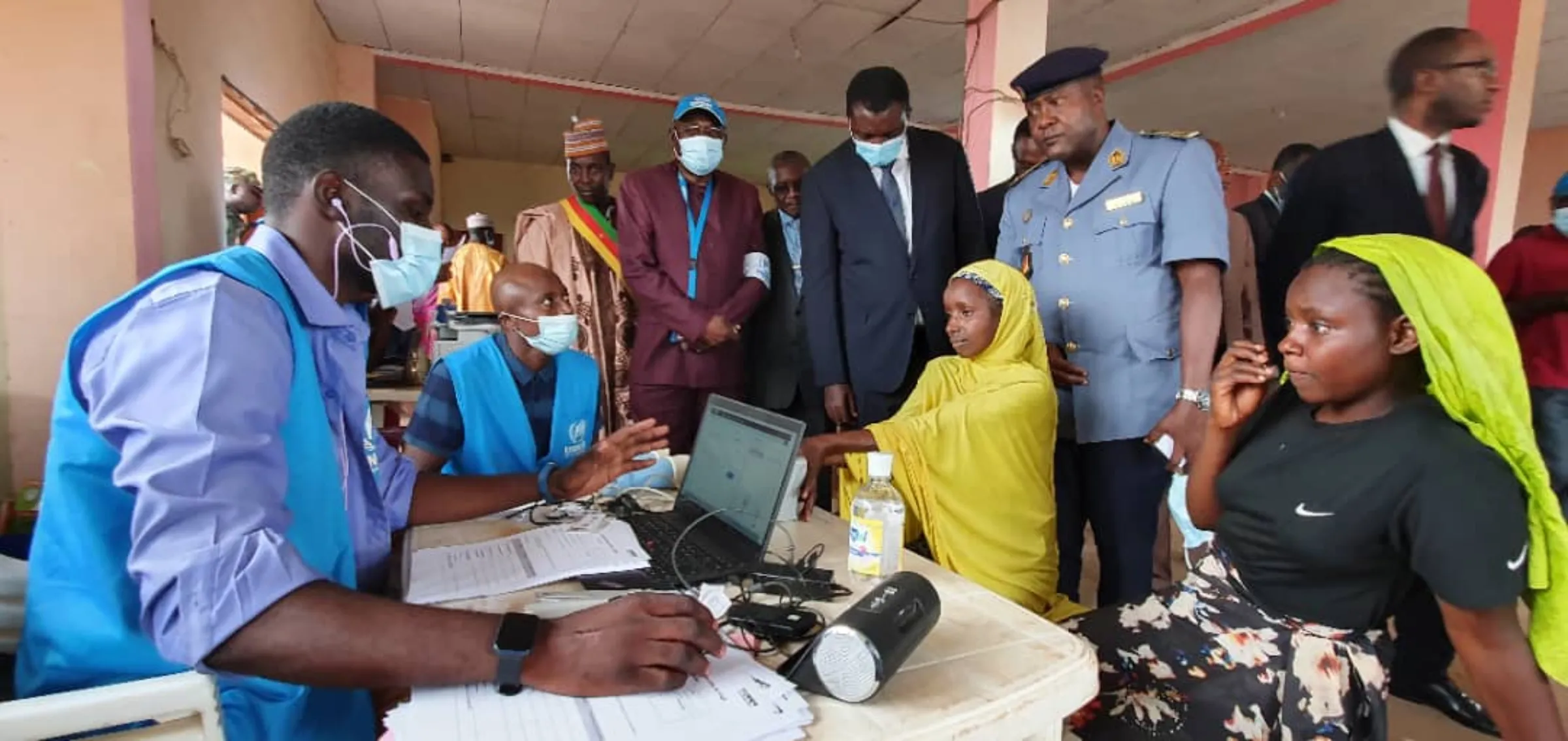 Officials supervise the delivery of digital ID cards to refugees from the Central African Republic at a camp in Cameroon