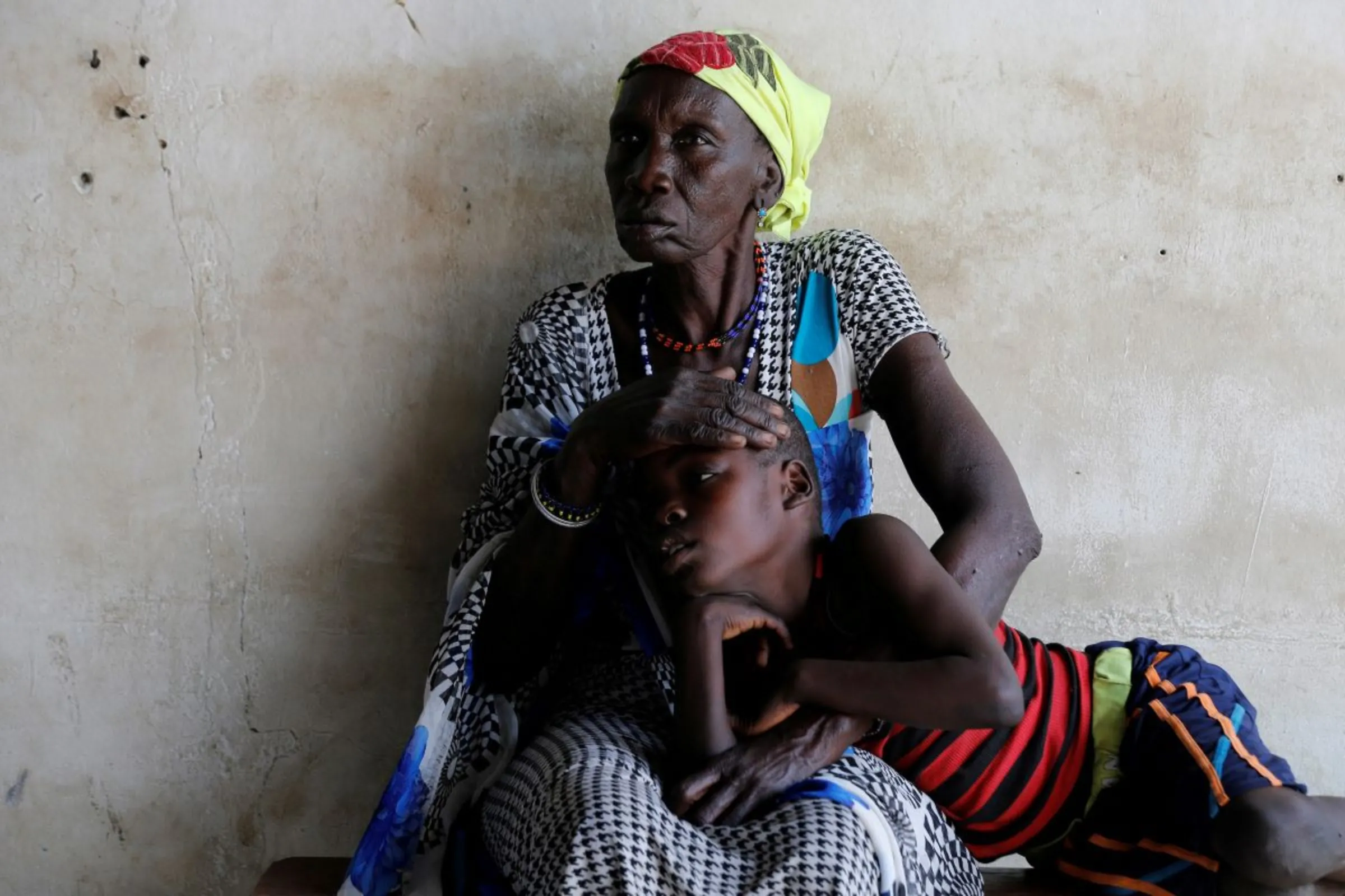A woman comforts her son, who is suffering from malaria, as they wait for treatment at a Medecins Sans Frontieres (MSF) run clinic in the village of Likuangole, in Boma state, east South Sudan, February 1, 2017