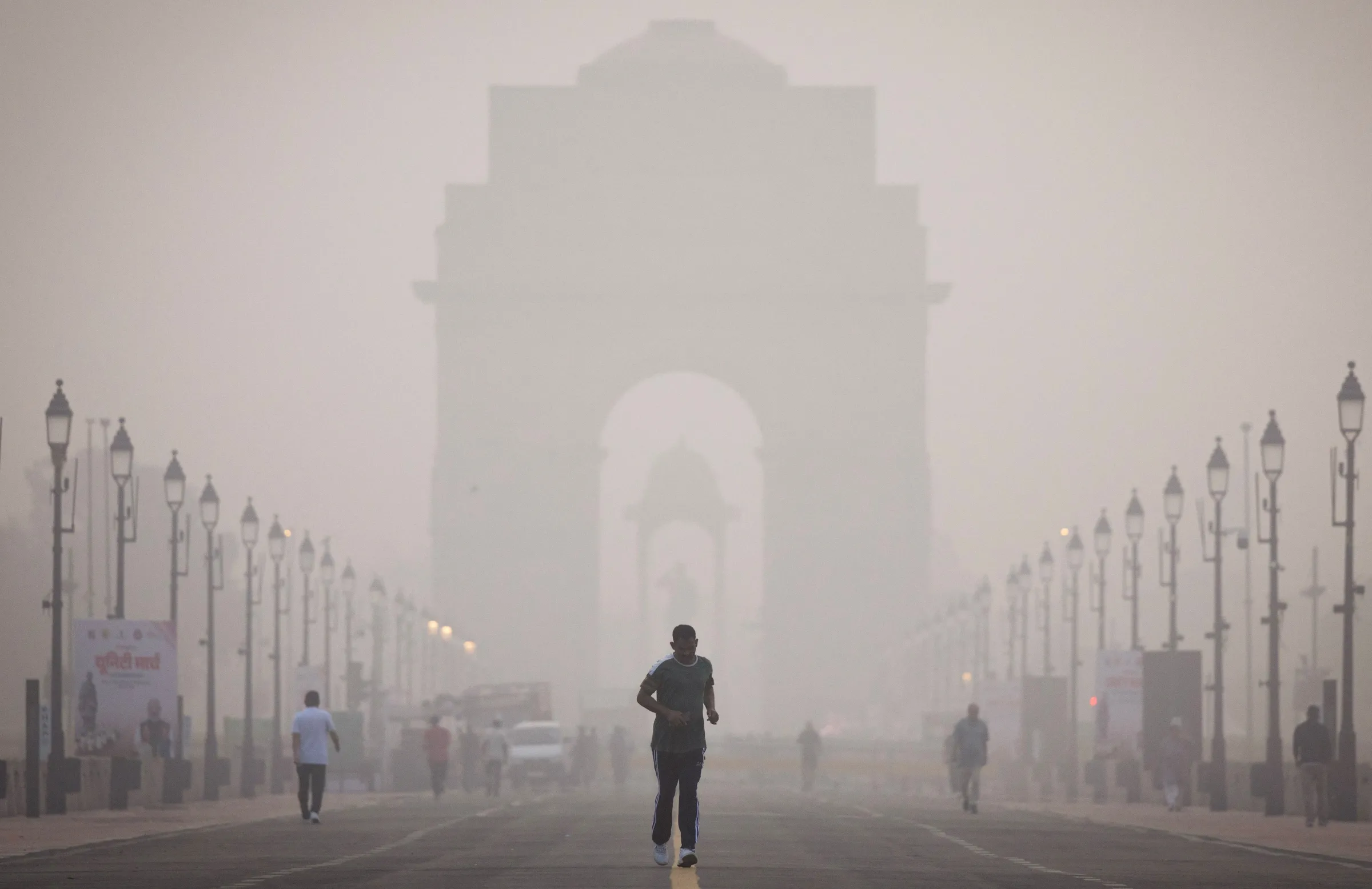 A man runs in front of India Gate on a smoggy morning in New Delhi, India October 31, 2025. REUTERS/Adnan Abidi