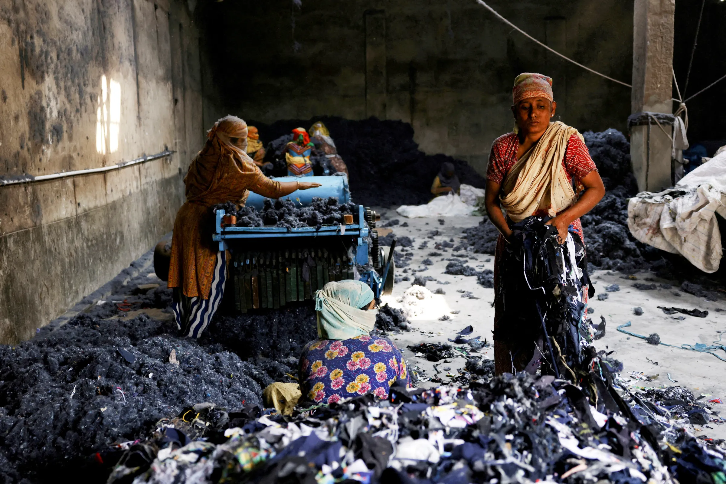 Women work in a factory where fabric waste from garments is transformed into cotton to make mattresses, in Narayanganj, Bangladesh, February 5, 2025. REUTERS/Mohammad Ponir Hossain