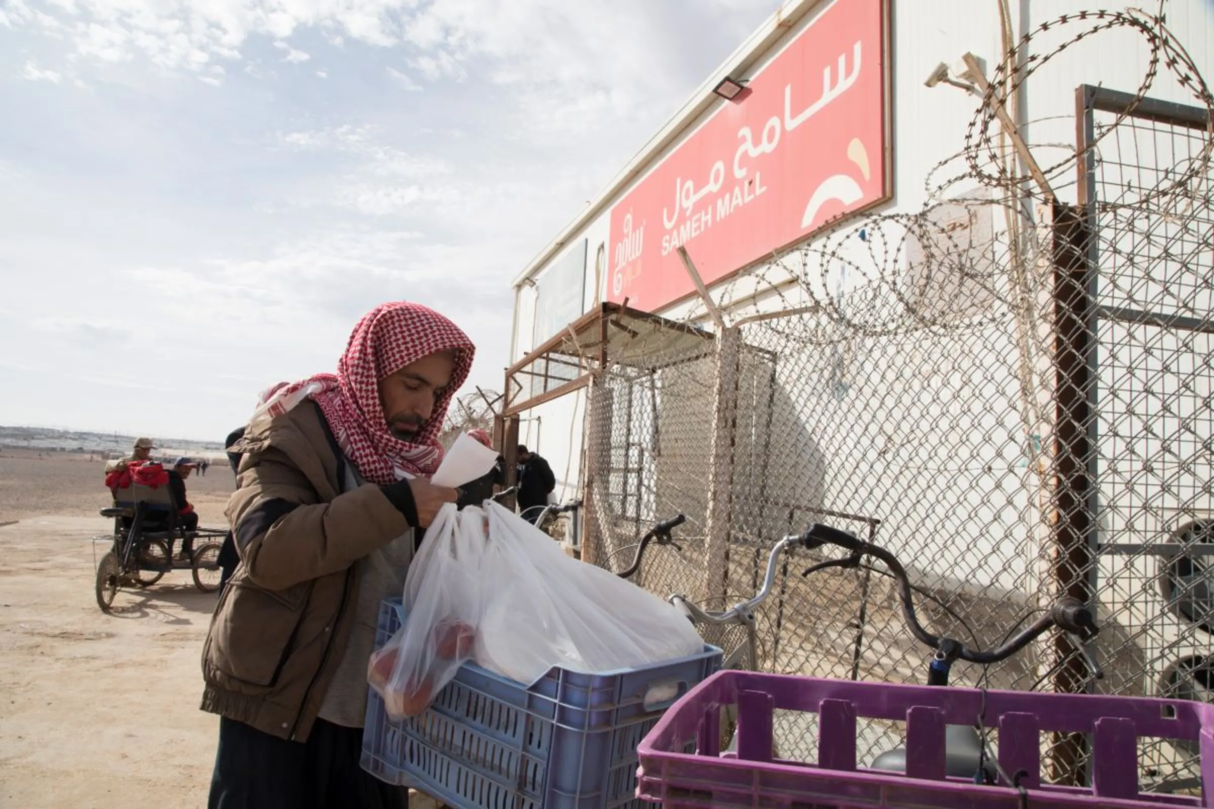 Abedalrazak Ali Mohammad, 41, loads his groceries unto his bicycle outside of Sameh Mall in Azraq, Jordan. November 27, 2022