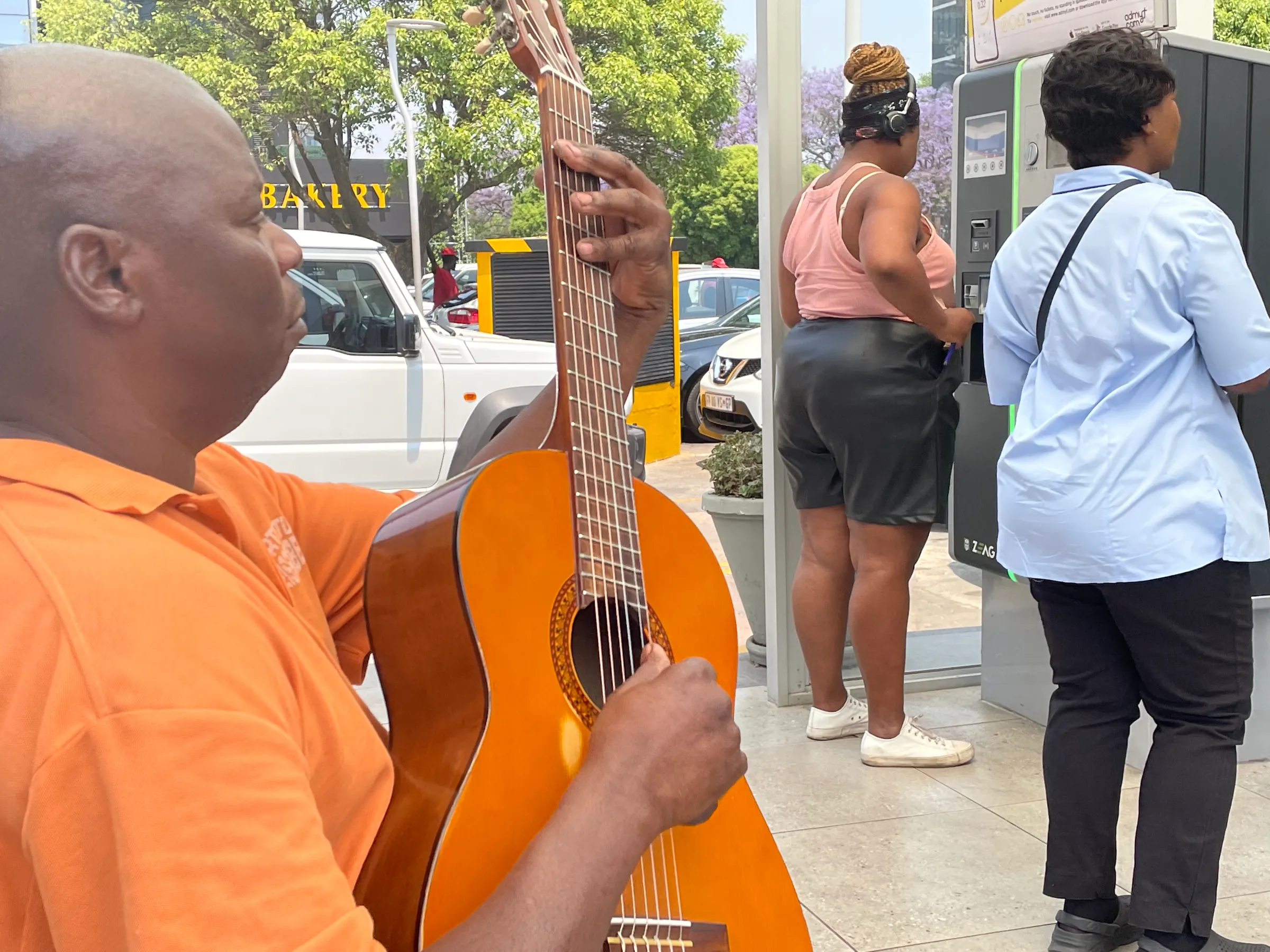 Thomas Nhassavele plays a guitar alongside a parking pay point in Rosebank Mall in Johannesburg, South Africa, October 7, 2022. Thomson Reuters Foundation/Kim Harrisberg