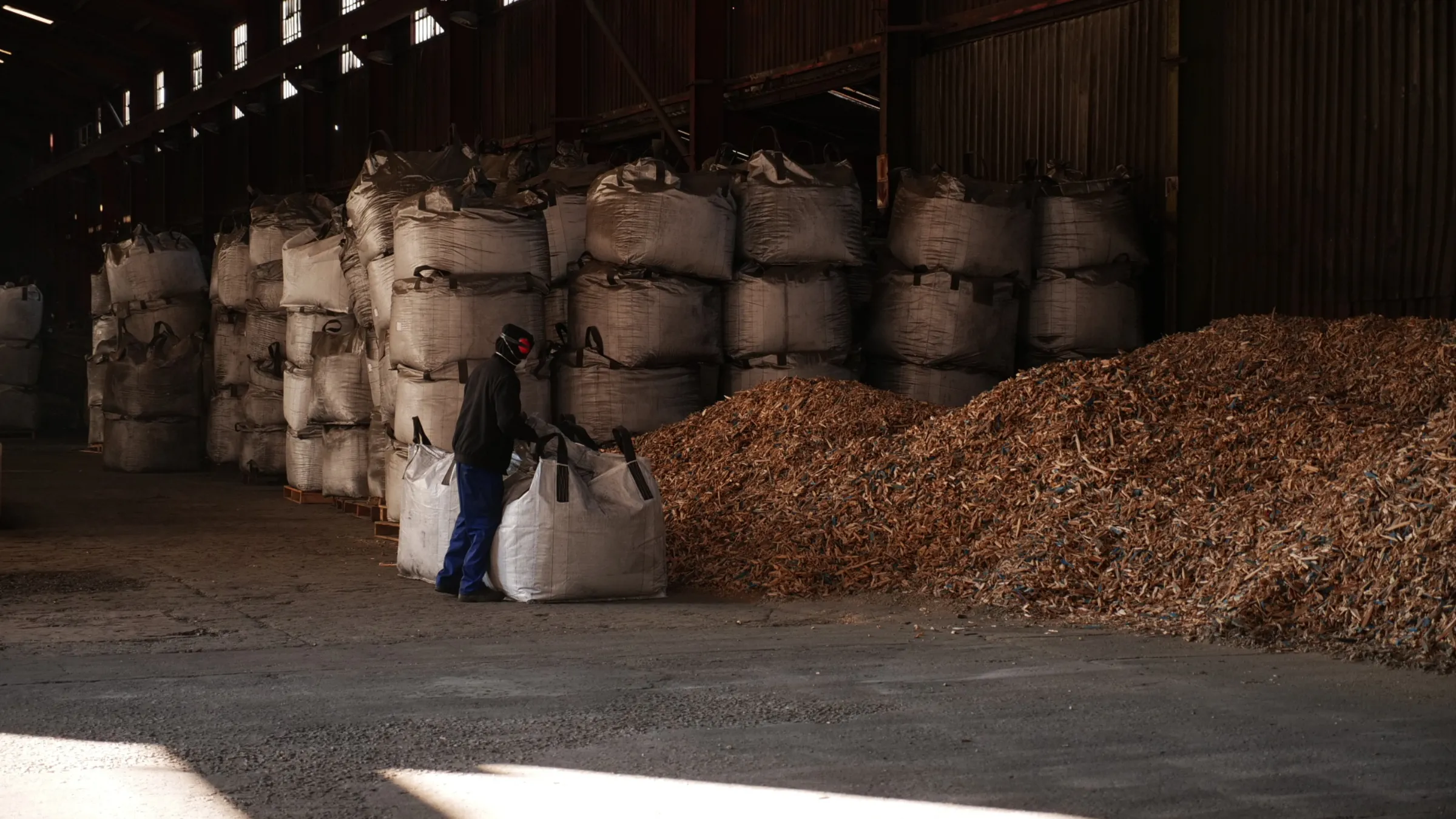 A worker at Adsorb’s charcoal plant opens a bag filled with wood chips in Brakpan, Johannesburg, South Africa, June 8, 2025. Thomson Reuters Foundation/Kim Harrisberg