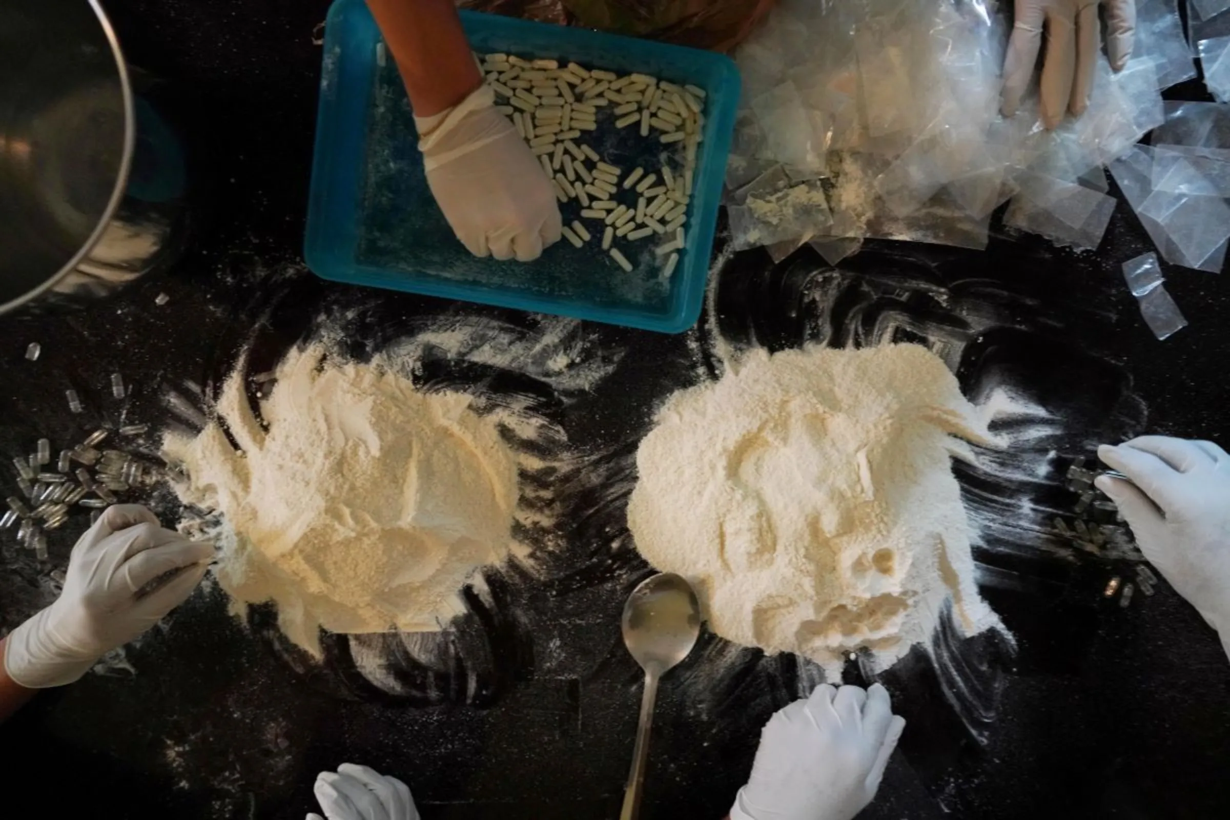 Members of the Sinaloa Cartel prepare capsules with methamphetamine in a safe house in Culiacan, Mexico, April 4, 2022. REUTERS/Alexandre Meneghini