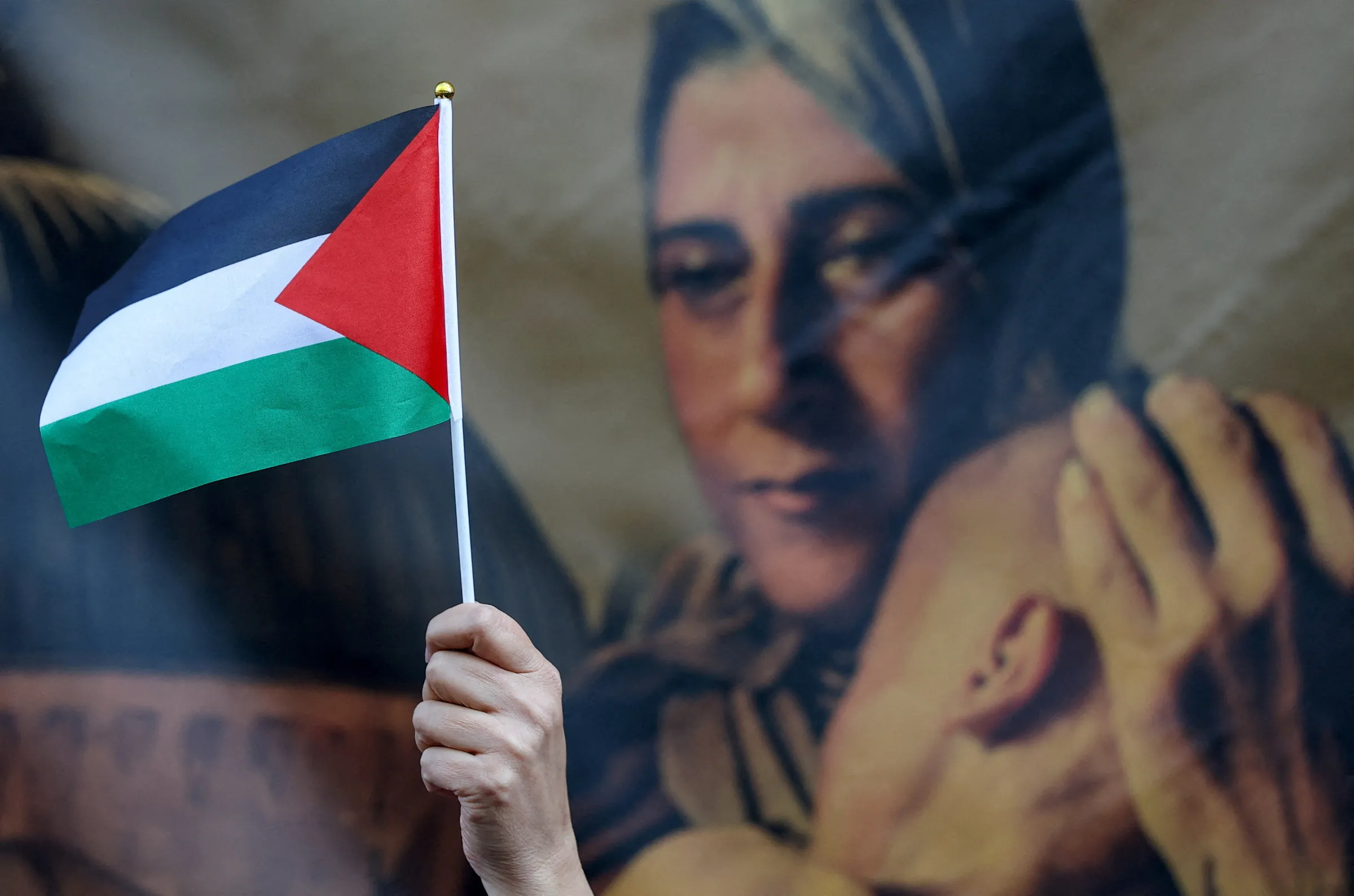 An attendee holds a Palestinian flag during a ceremony at the headquarters of the Palestinian mission to the United Kingdom, in London, Britain, September 22, 2025. REUTERS/Toby Melville