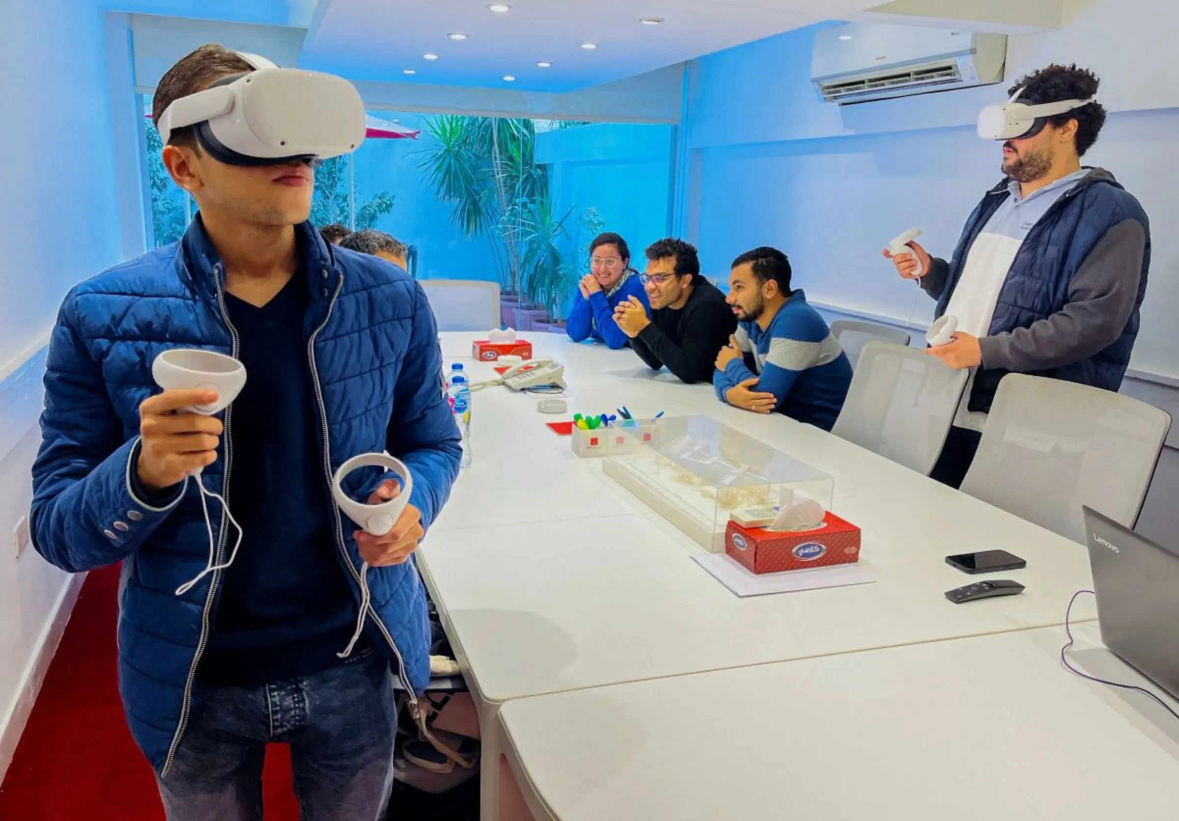 Designers of a virtual city take a virtual tour on the Metaverse while wearing VR headsets and handles in Cairo, Egypt December 5, 2022. REUTERS/Dina Sakr