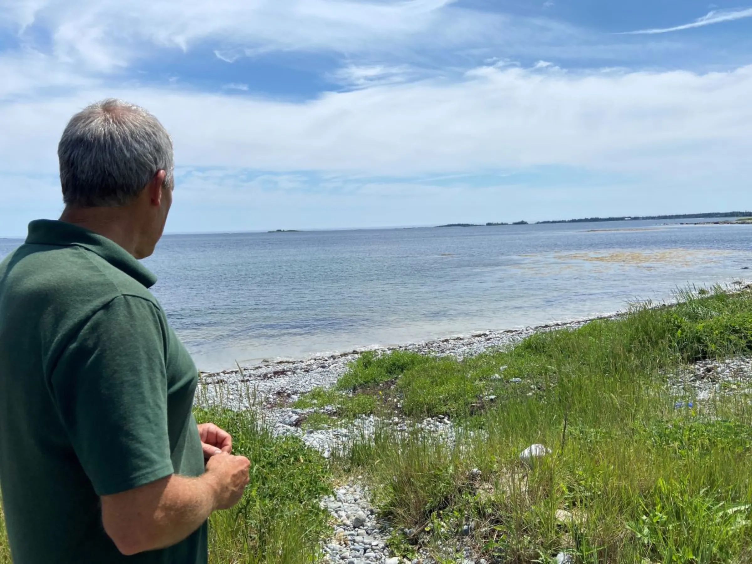 Matthew Roy, owner of Coastal Grove Farm, is pictured near water that stretches out into the Atlantic Ocean in Nova Scotia, Canada, July 24, 2023