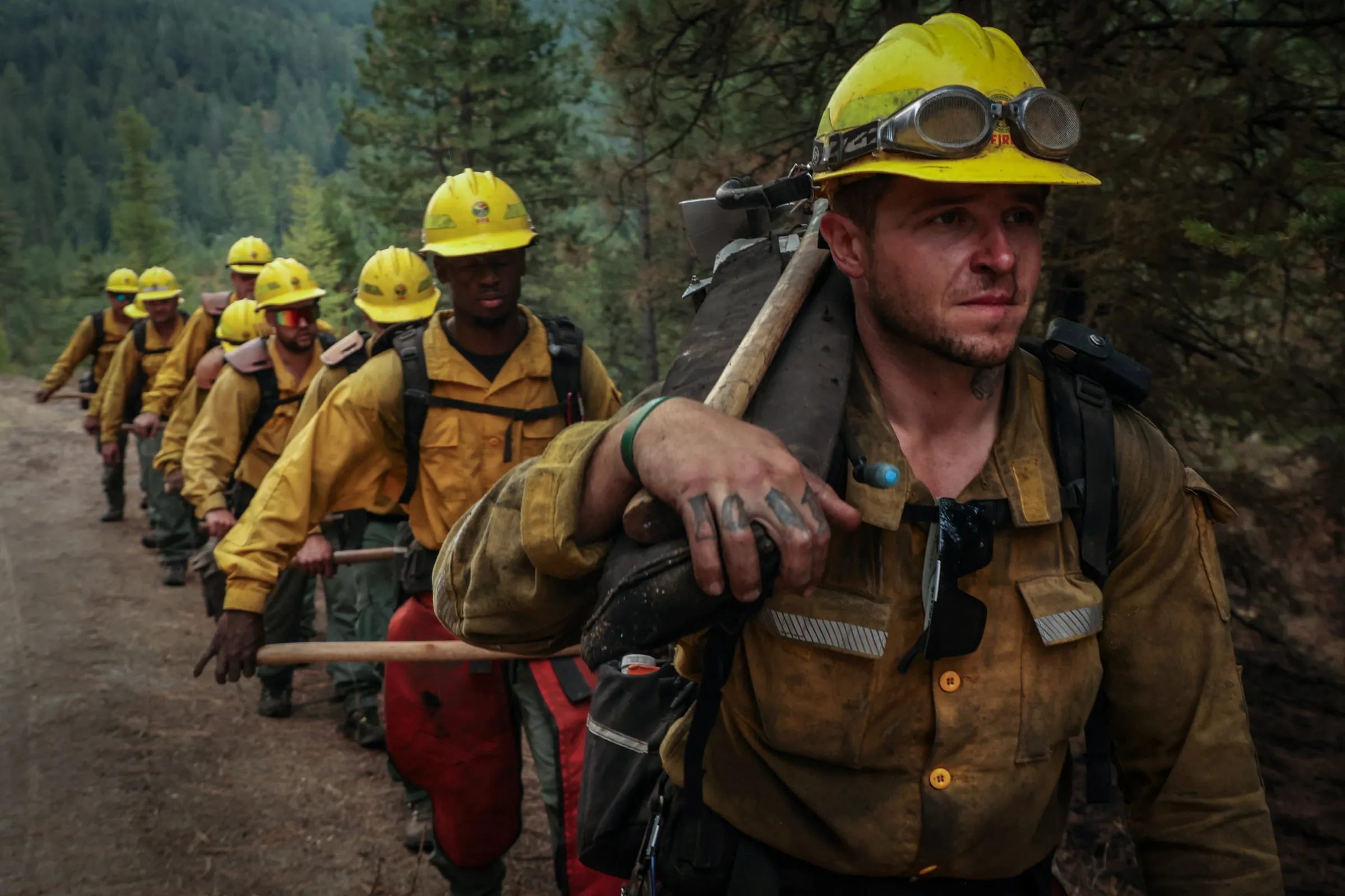 A group of partially-incarcerated firefighters march along a forest road on deployment at the Oregon fire near Deer Park, Washington, U.S., August 30, 2023. REUTERS/Matt Mills McKnight