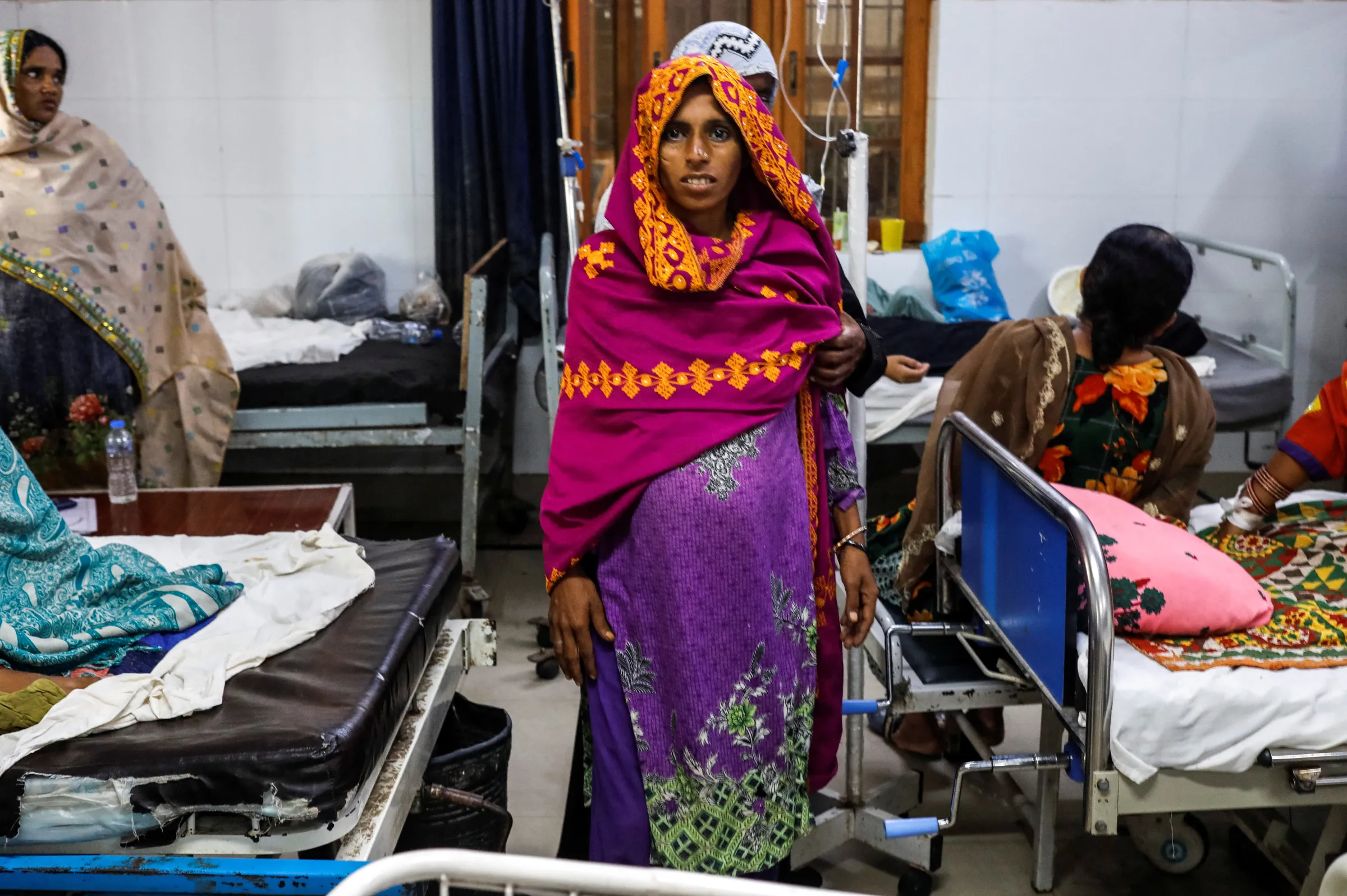 A woman who is nine-months-pregnant walks with the help of a relative while being admitted to a hospital, following rains and floods during the monsoon season in Sehwan, Pakistan September 7, 2022. REUTERS/Akhtar Soomro
