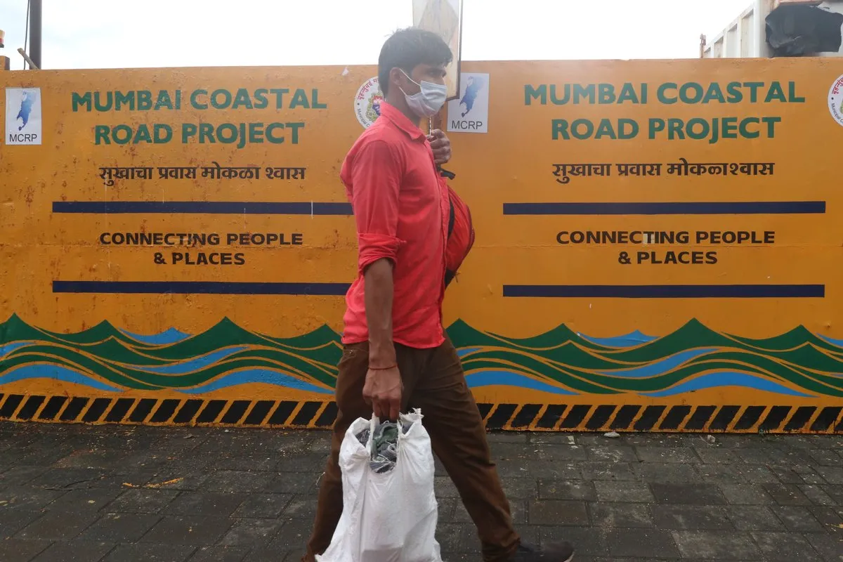 A man walks past barricades erected along a new coastal road project, in Mumbai, India, September 8, 2021