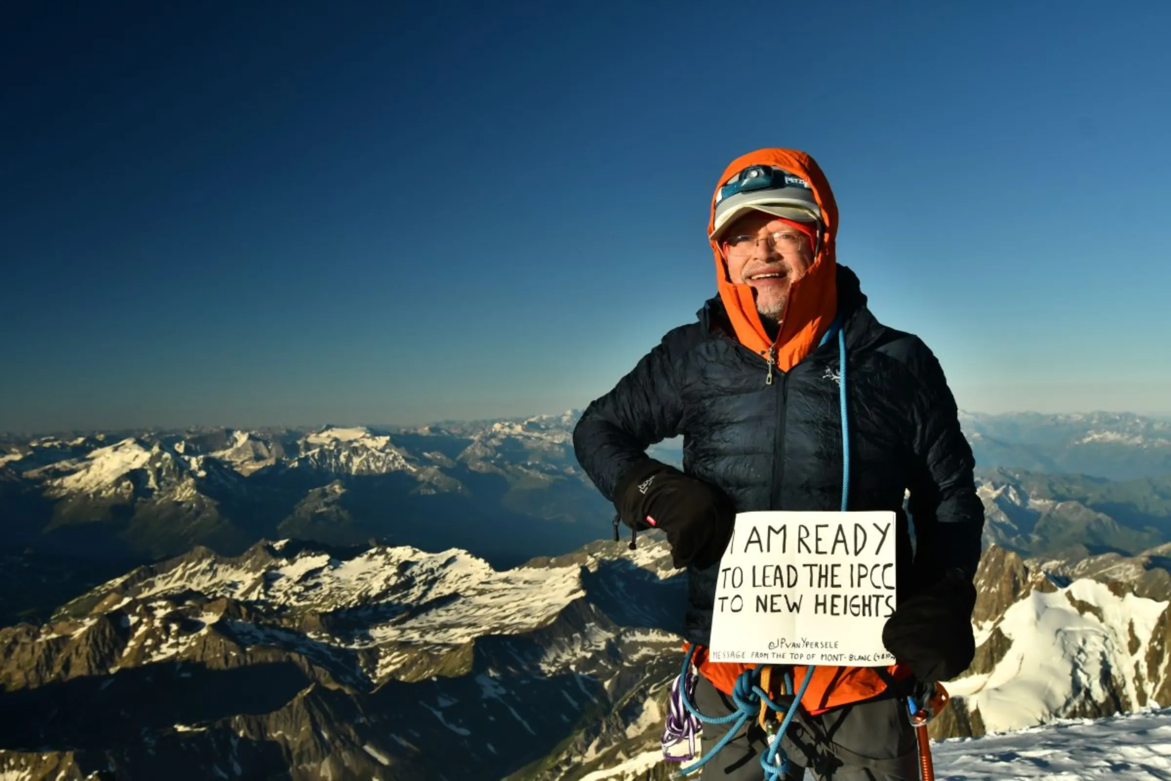 Jean-Pascal van Ypersele, a Belgian professor of environmental sciences and candidate to lead the U.N.’s Intergovernmental Panel on Climate Change, stands atop Mont Blanc in 2020 with a banner reading “I am ready to lead the IPCC to new heights”