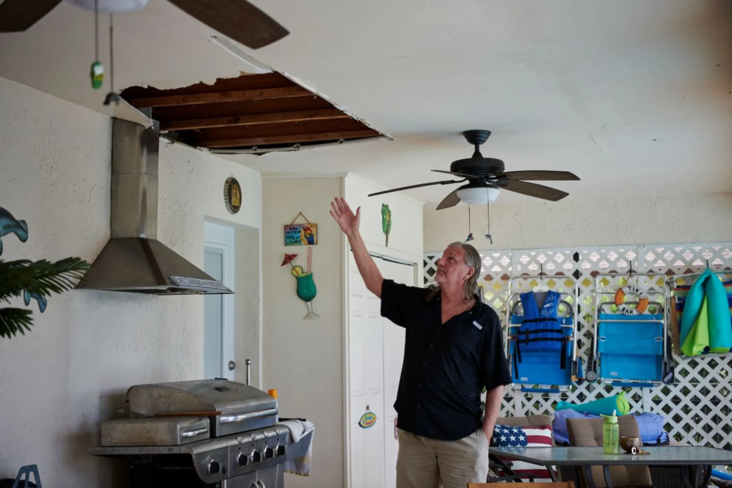 Tom Paulits gestures toward Hurricane Ian-related damage at his home in Cape Coral, Florida, USA, May 23, 2023