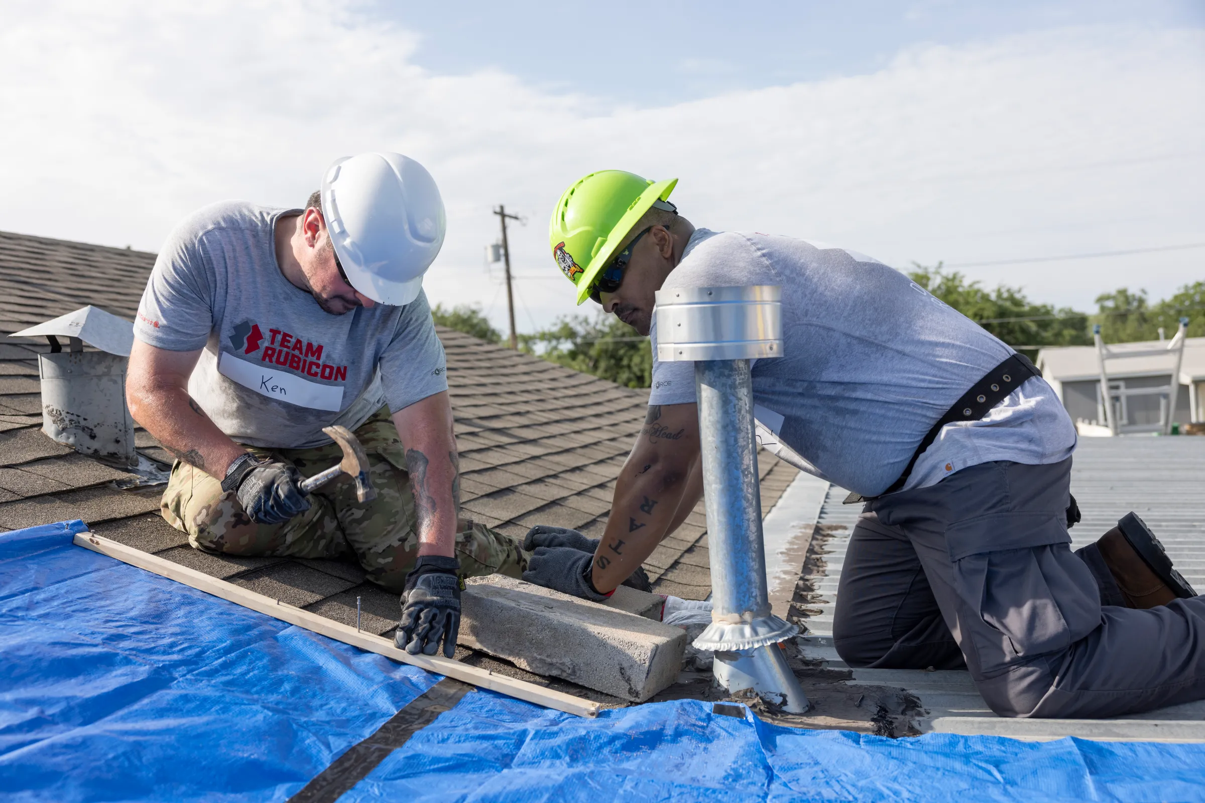 Team Rubicon volunteers tarp a damaged roof at a home following flooding in San Angelo, Texas, on August 15, 2025. Jamie Brown/Team Rubicon/Handout via Thomson Reuters Foundation
