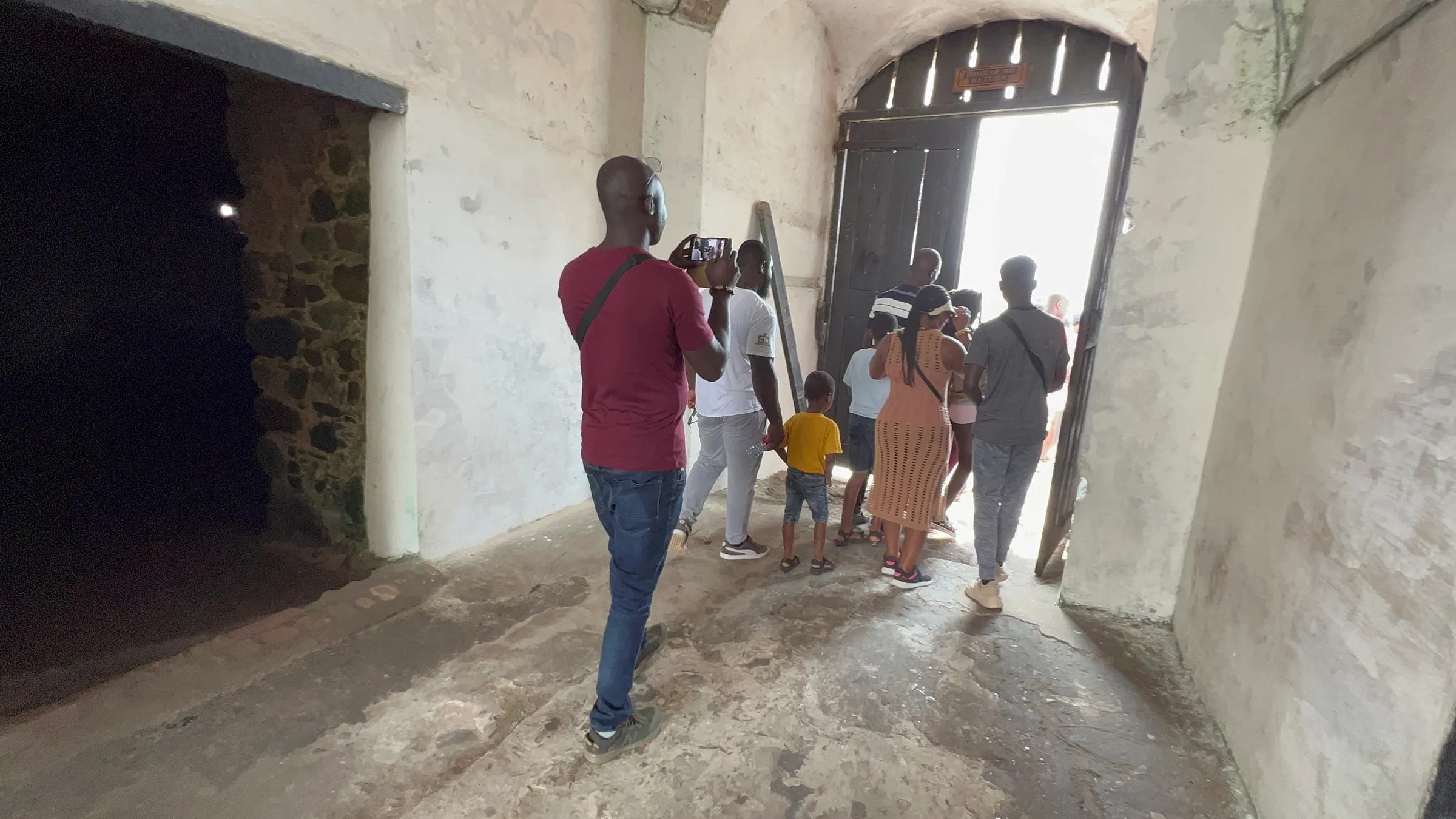 Tourists walk through the "Door of No Return" at Cape Coast Castle on the Cape Coast, Ghana on August 9, 2022.