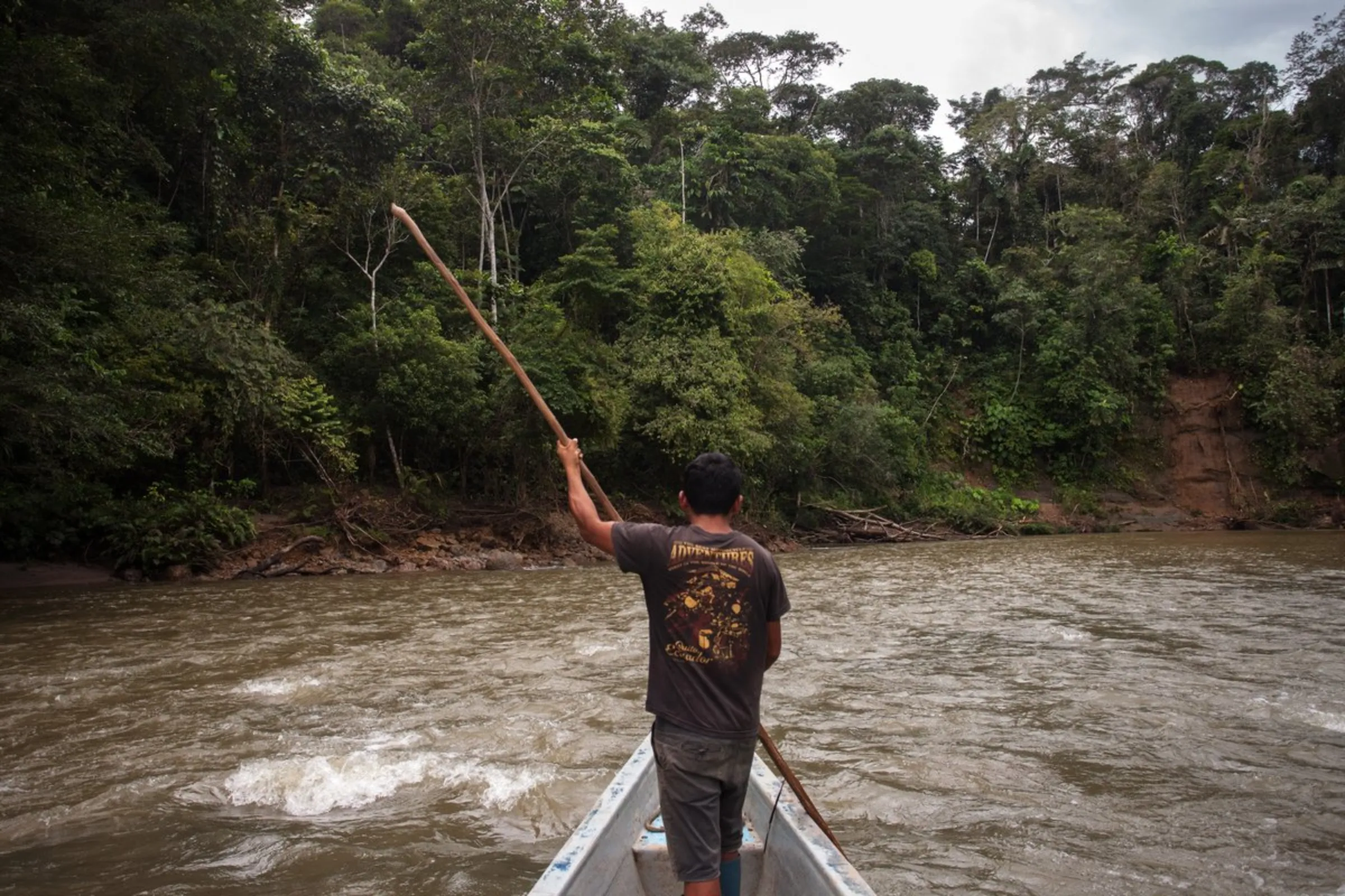 A man from the Waorani of Pastaza indigenous group navigates the choppy Curaray River in the Amazon province of Pastaza, Ecuador, on April 25, 2022