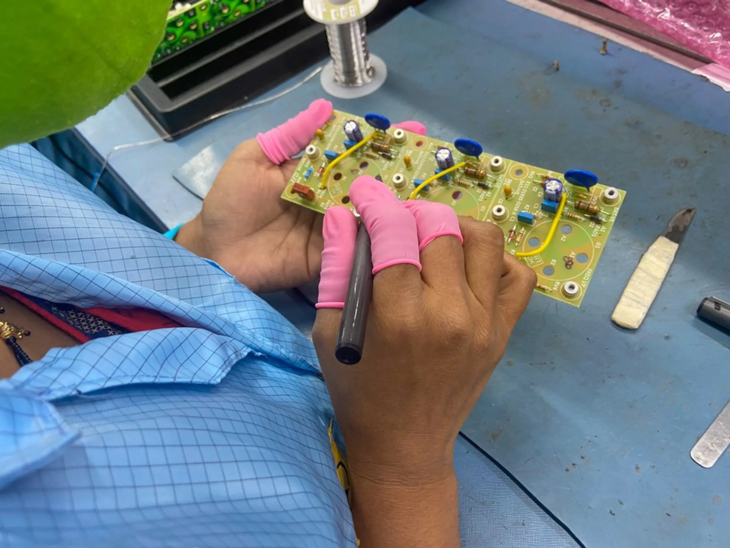 A worker assembles a circuit on the Kinetic Communications factory floor in Pune, India, April 20, 2022