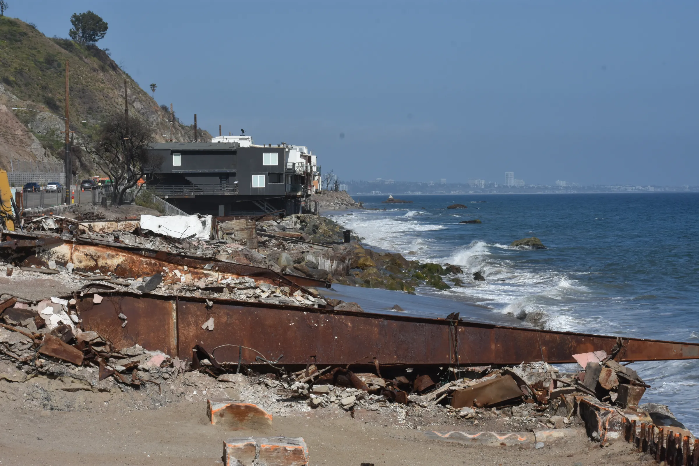 Intact homes perch on the sliver of beach by destroyed houses near Big Rock Beach, May 19, 2025. Rachel Parsons/Thomson Reuters Foundation