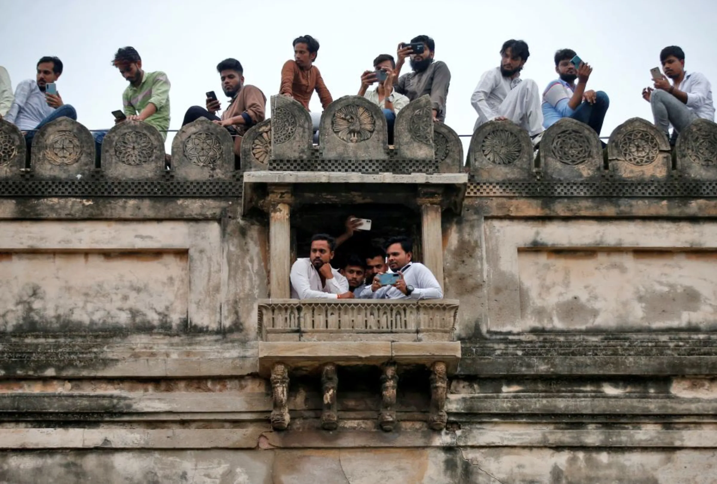 People use their mobile phones to record a Muharram procession by Shi'ite Muslim mourners marking Ashura in Ahmedabad, India, August 9, 2022