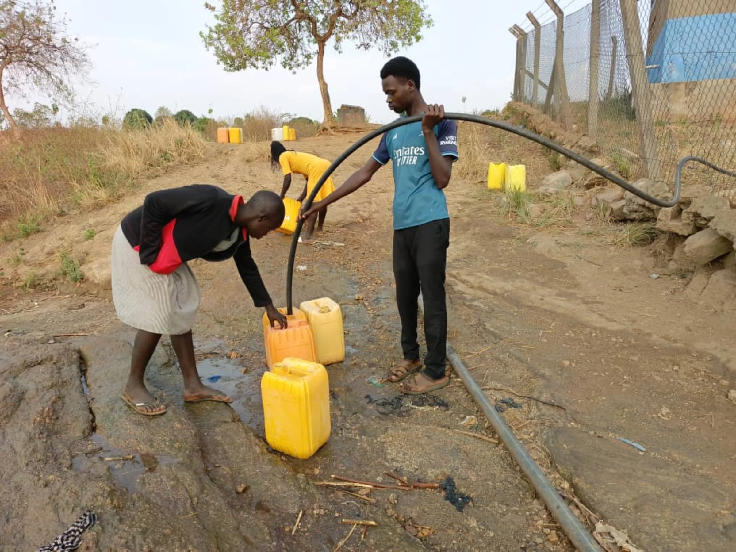 Refugees collect water from a tap in Bidibidi camp, February 2025. Yesua Aliki/Handout via Thomson Reuters Foundation
