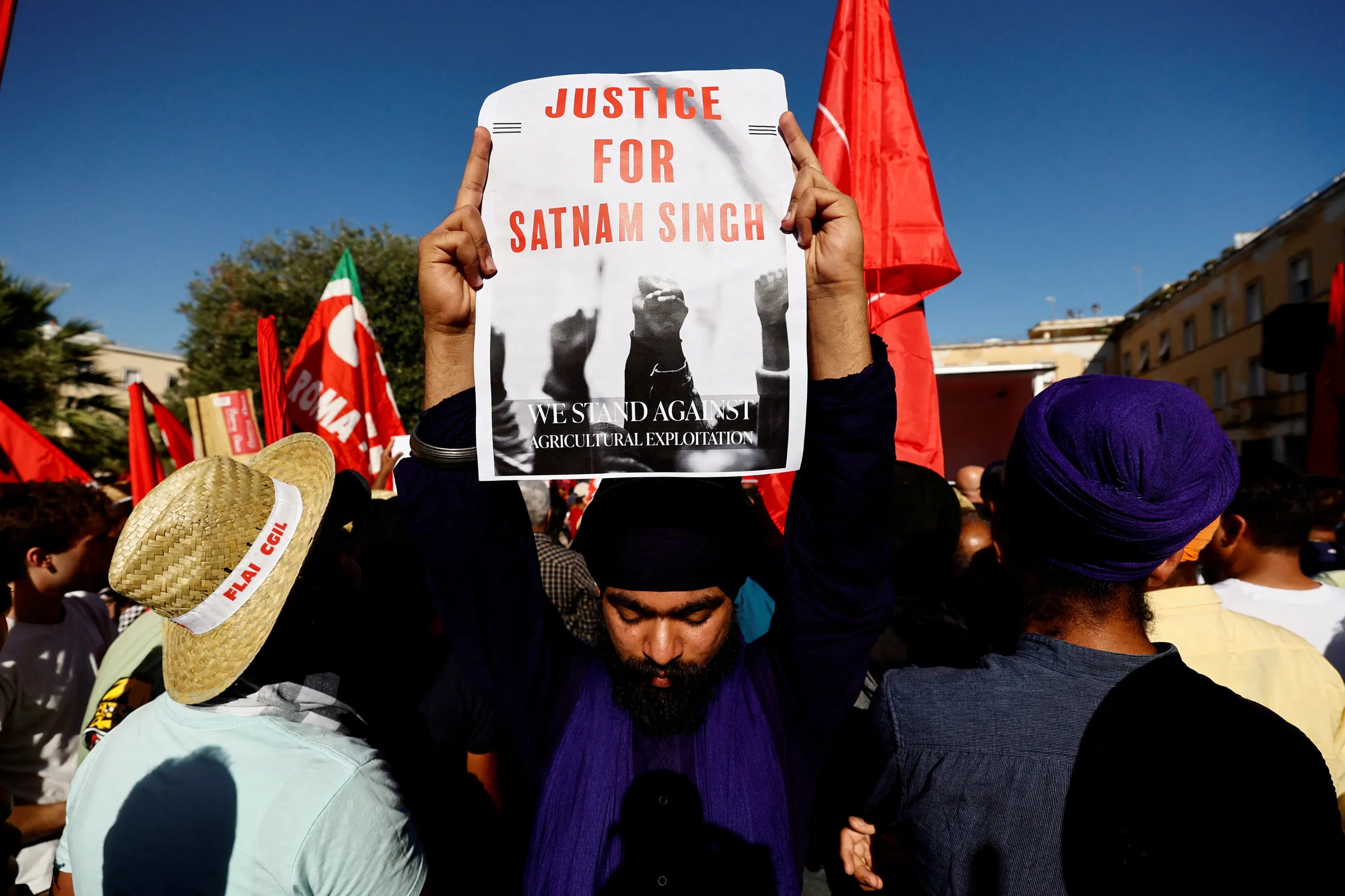 A demonstrator holds a placard that reads: 'Justice for Satnam Singh' during a protest in Latina, Italy June 22, 2024. REUTERS/Stringer