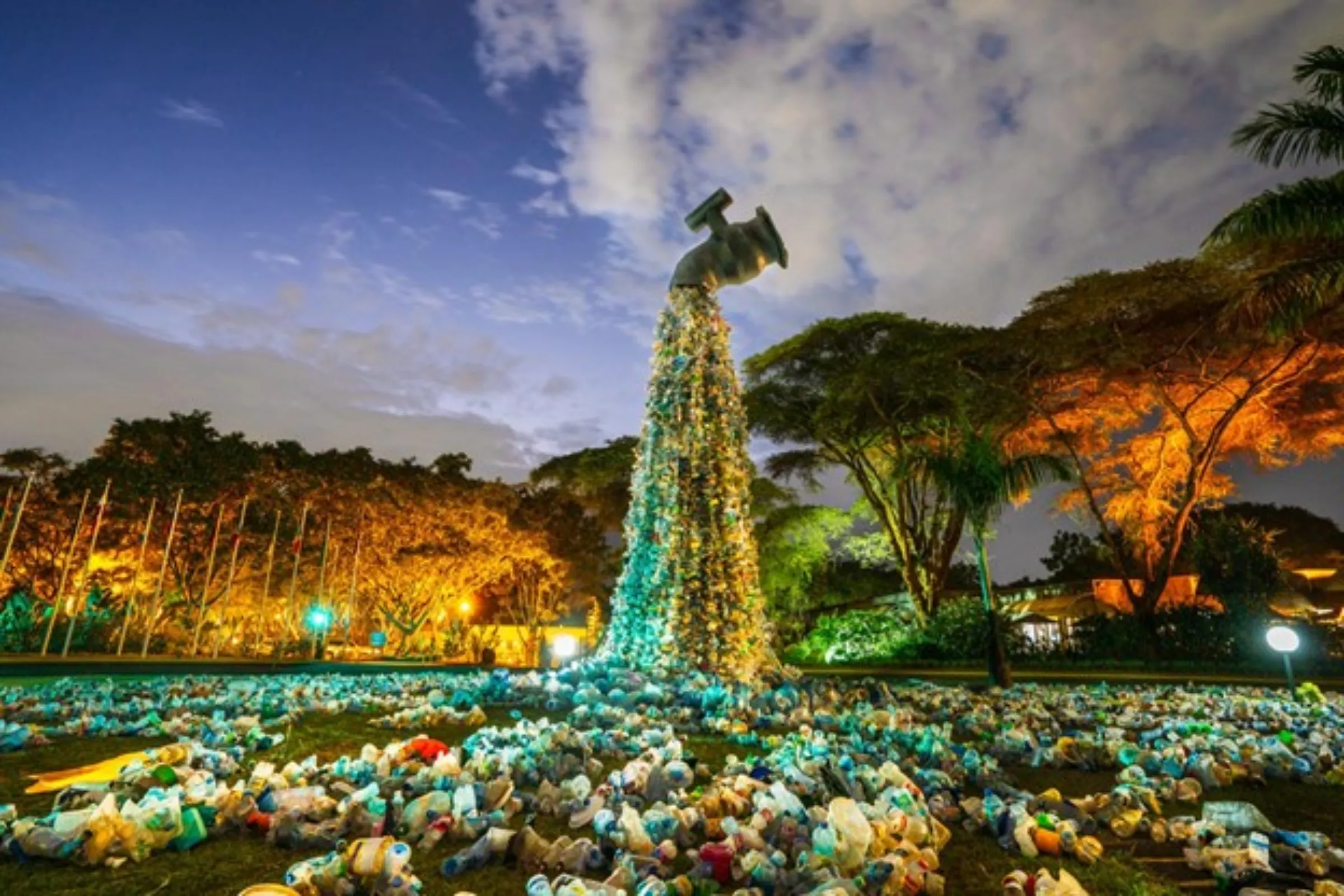 A tap made of plastic waste by artist Benjamin Von Wong to highlight the damage from single-use plastics is shown with a backdrop of trees and clouds at the United Nations compound in Nairobi, Kenya. Handout picture via Thomson Reuters Foundation/Benjamin Von Wong