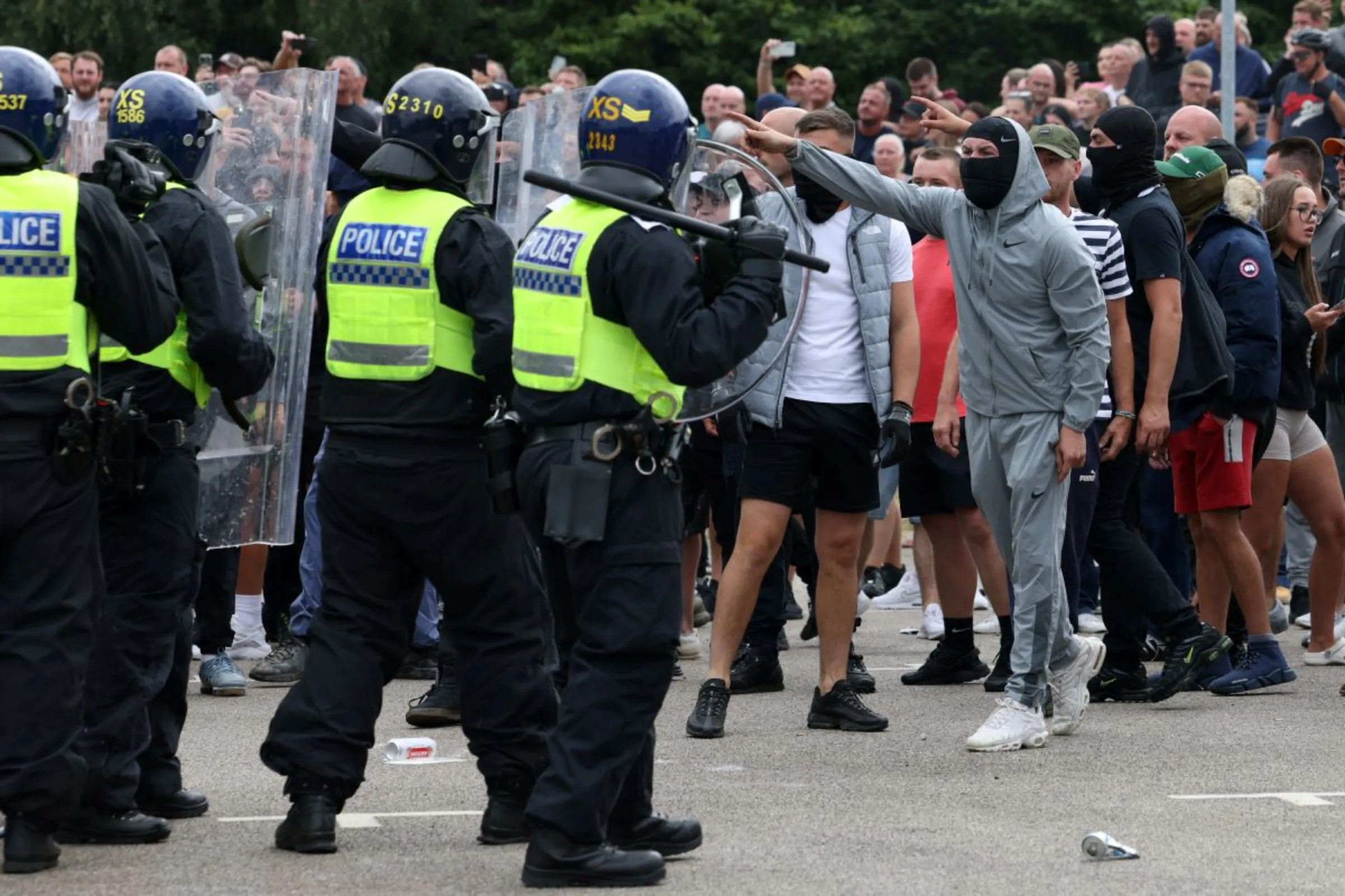 Demonstrators face police officers outside a hotel during an anti-immigration protest, in Rotherham, Britain, August 4, 2024. REUTERS/Hollie Adams