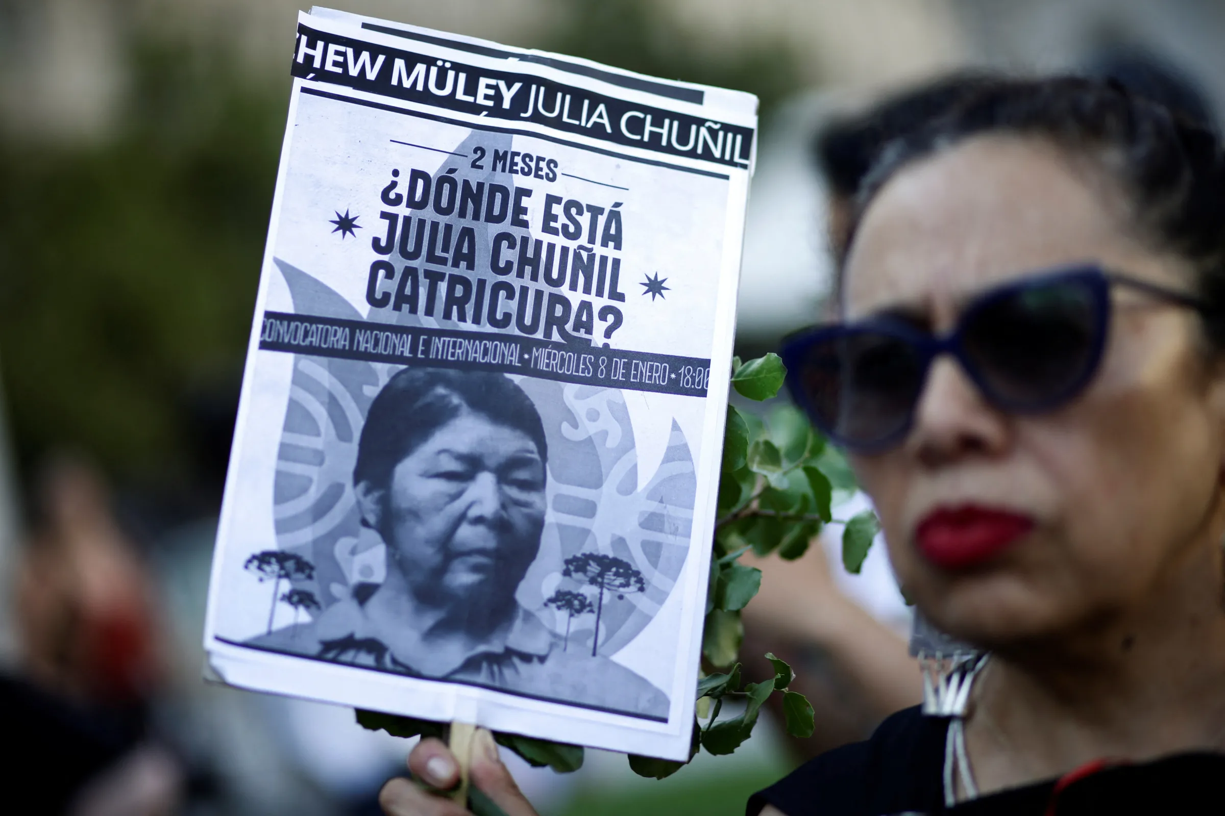 A woman holds a sign during a protest against the disappearance of Mapuche leader Julia Chunil, in front of La Moneda presidential palace in Santiago, Chile January 8, 2025. REUTERS/Juan Gonzalez