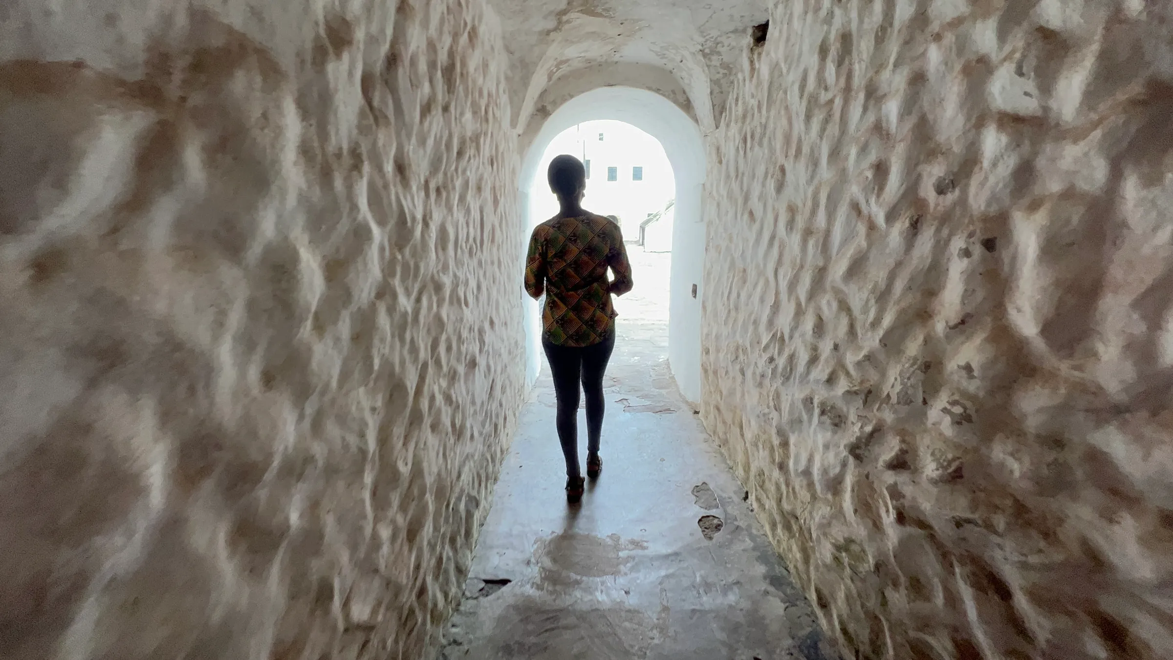 A tour guide walks through a narrow passage way at Elmina Castle, Central region, Ghana. August 9, 2022